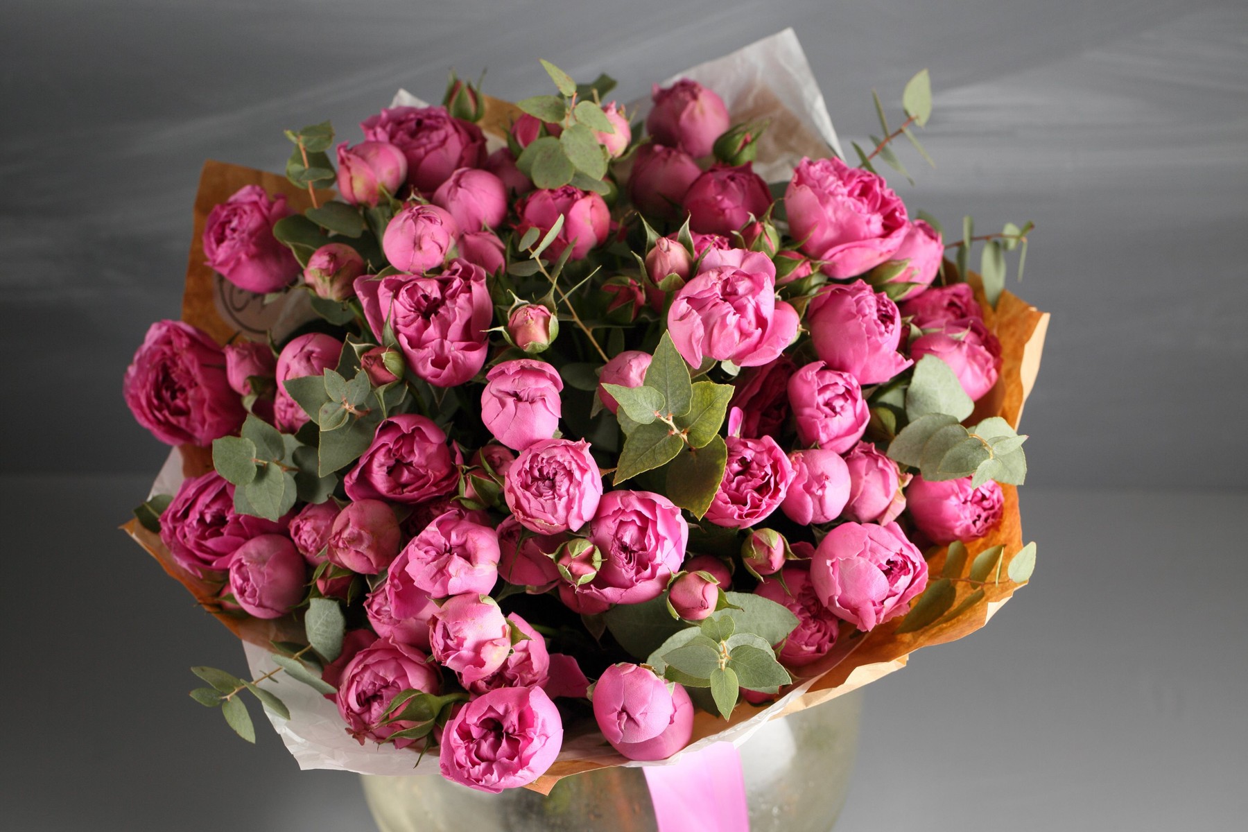 Rose peony Misty Bubbles. Bouquet flowers of pink roses in glass vase on dark grey rustic wooden background. Shabby chic home decor.