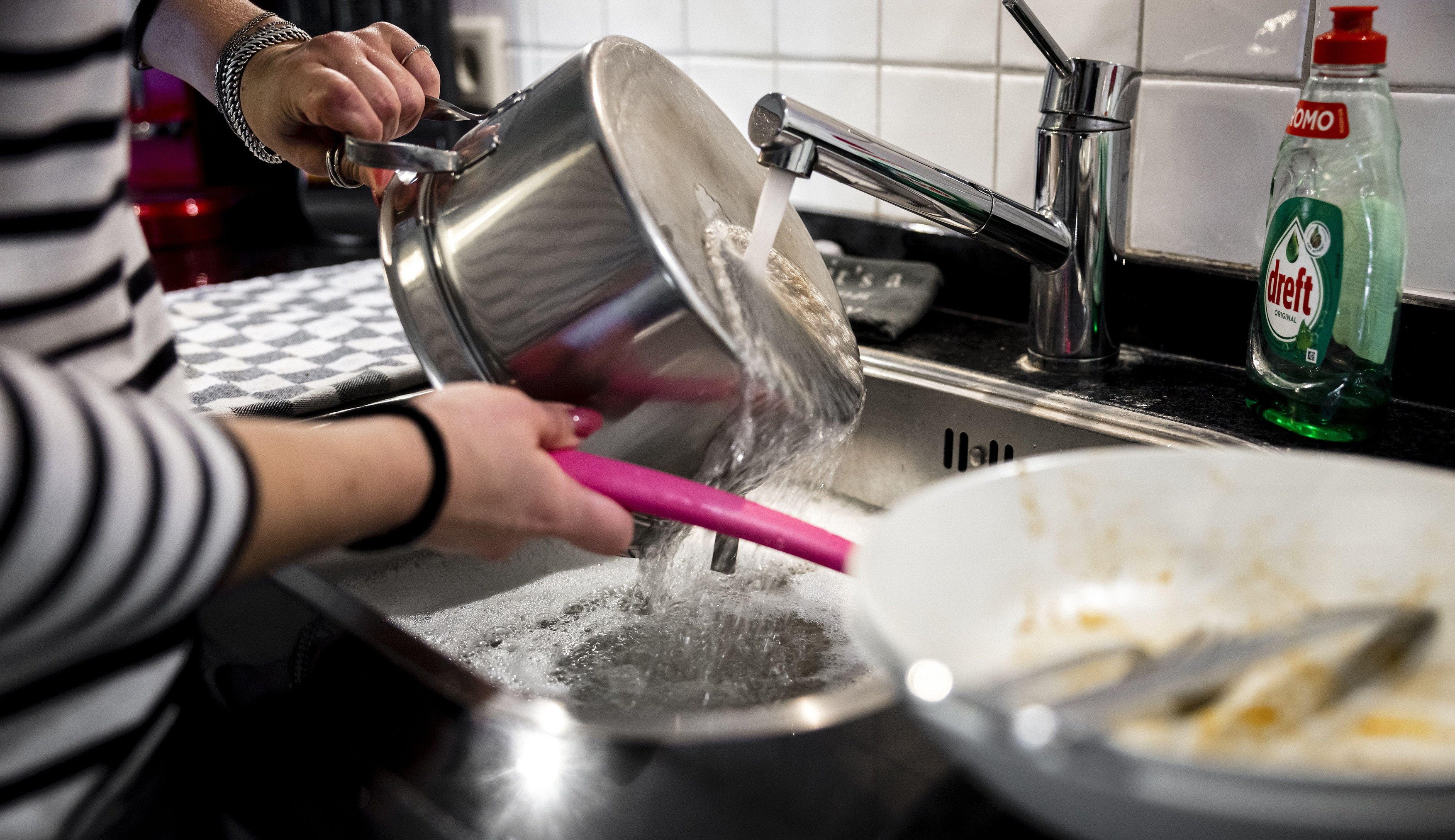 2022-09-29 13:59:18 ILLUSTRATIVE - A woman is washing dishes by hand to save energy. Gas supplies from Russia are declining as a result of the war with Ukraine. ANP ROB ENGELAAR netherlands out - belgium out