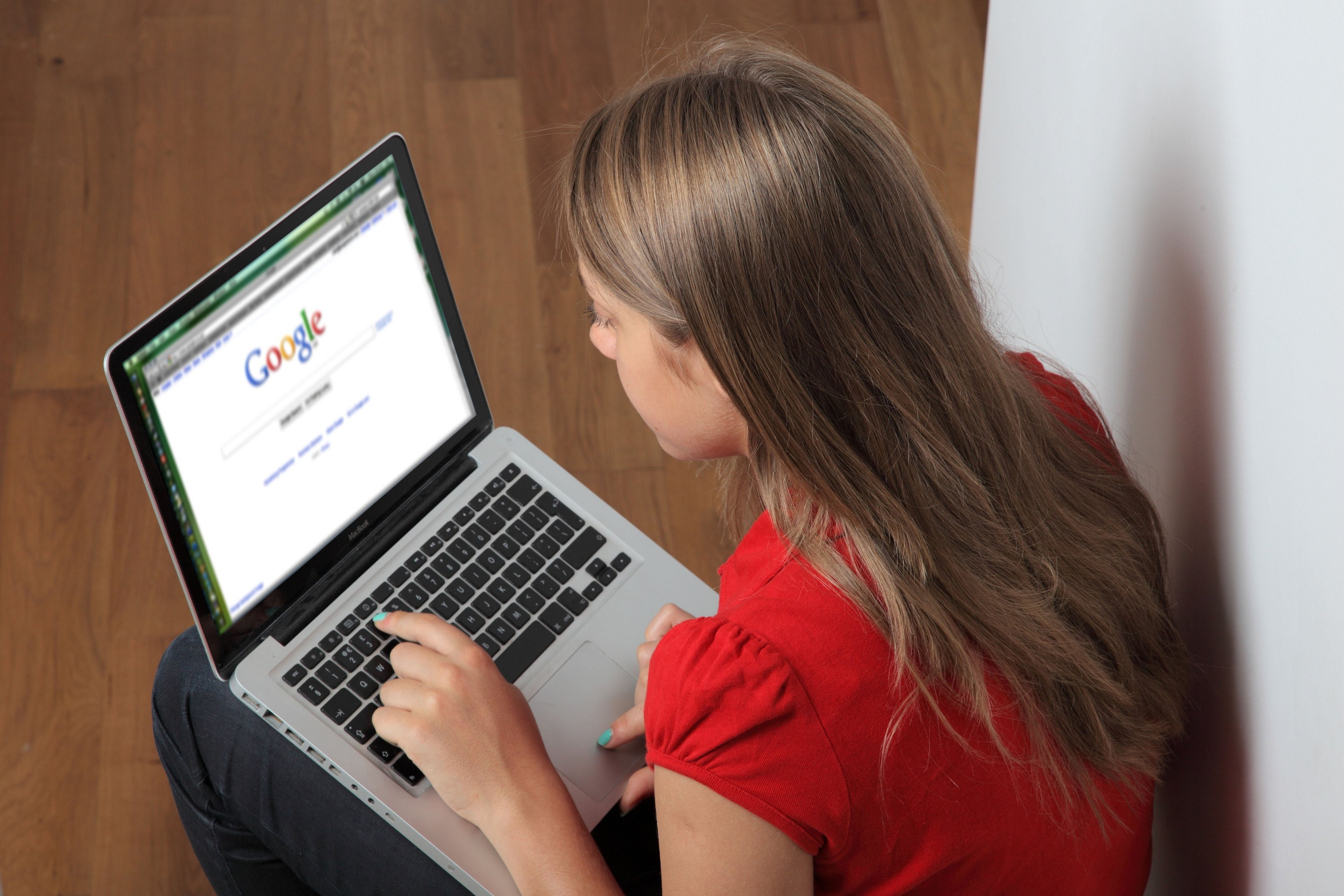 Young female using laptop on Google.