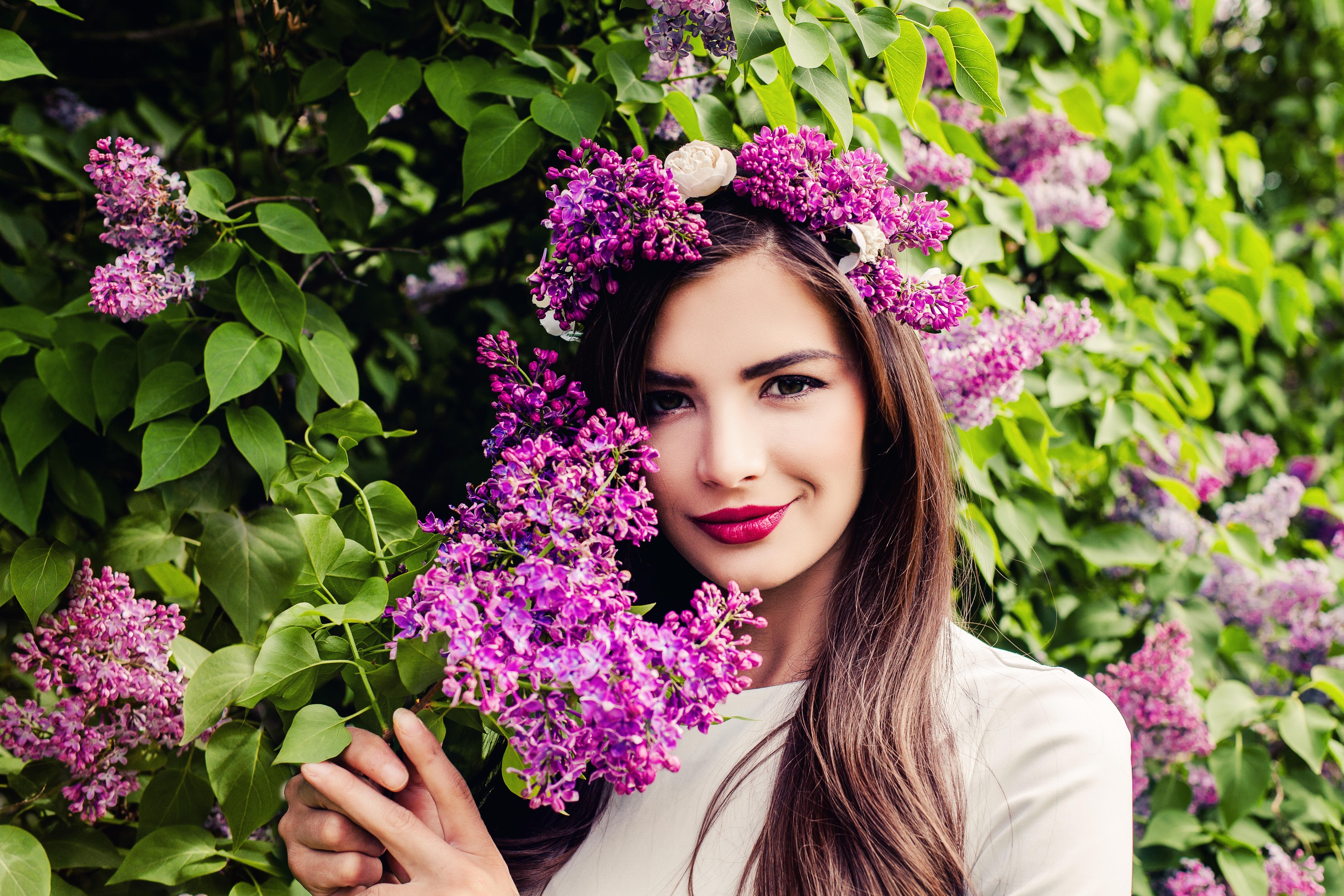 Young Brunette Woman with Long Healthy Hair, Makeup and Flower Wreath on Floral Background
