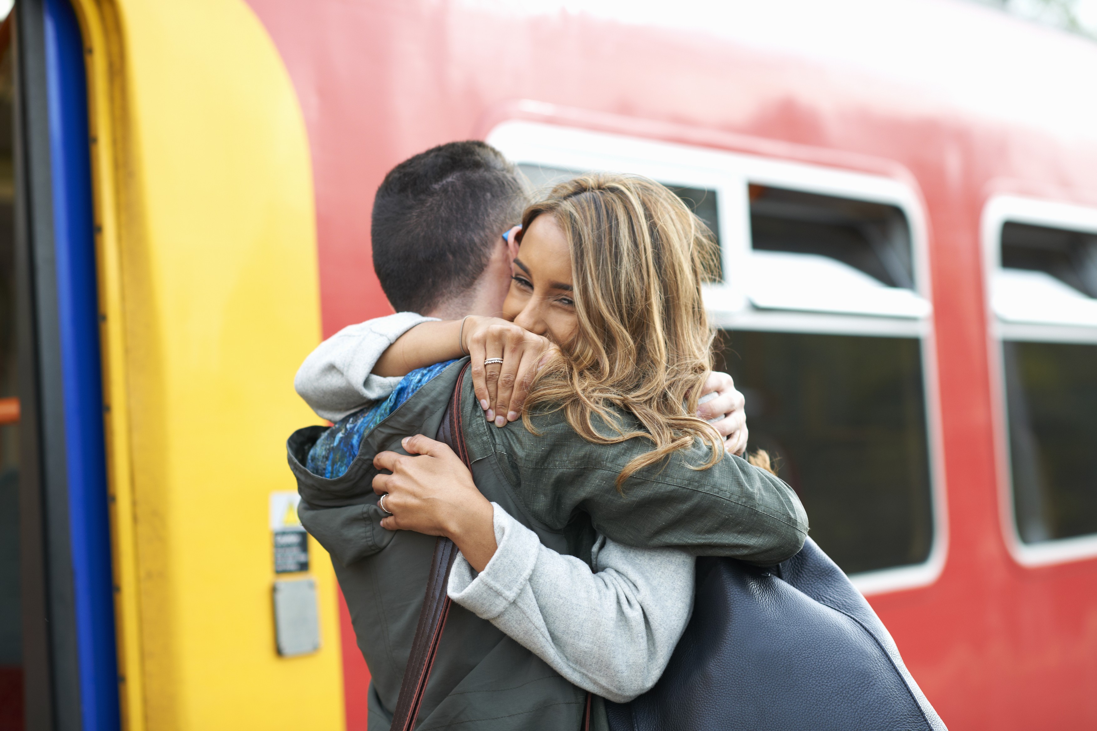 Heterosexual couple hugging at railway station