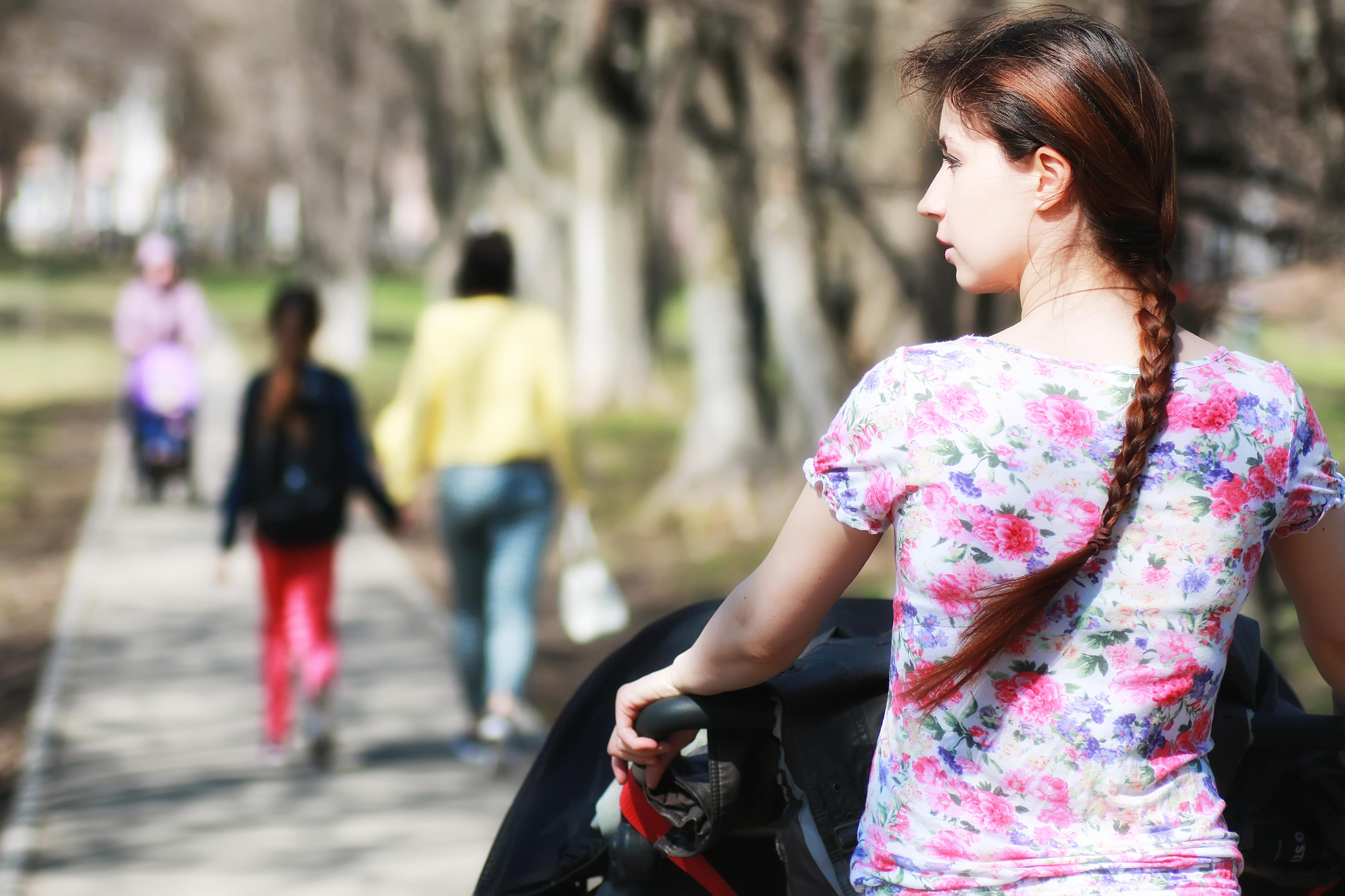 young mother with stroller in park