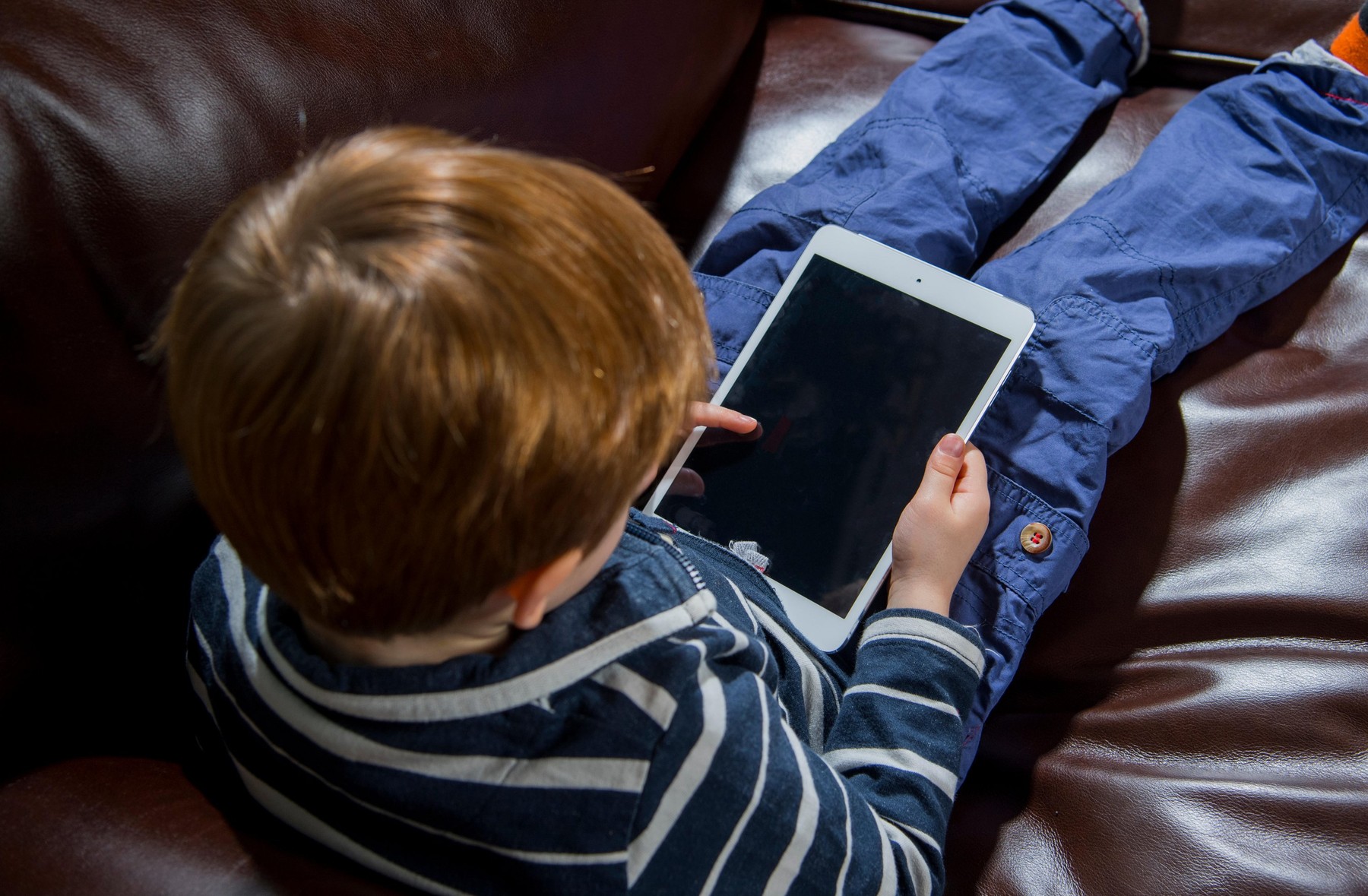 Child using technology. 5 year old boy with a tablet computer or iPad