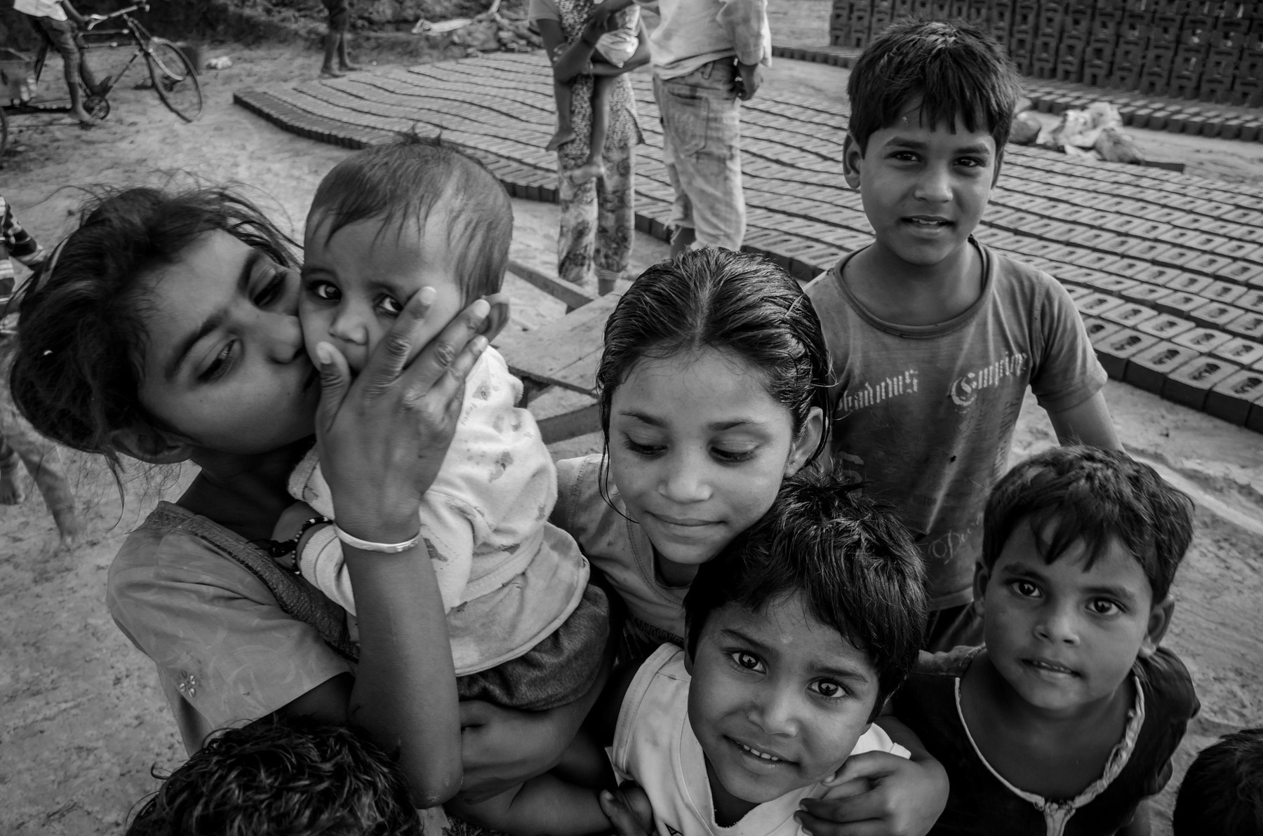 AMRITSAR, PUNJAB, INDIA - 21 APRIL 2017 : monochrome picture of Indian kids holding their younger siblings