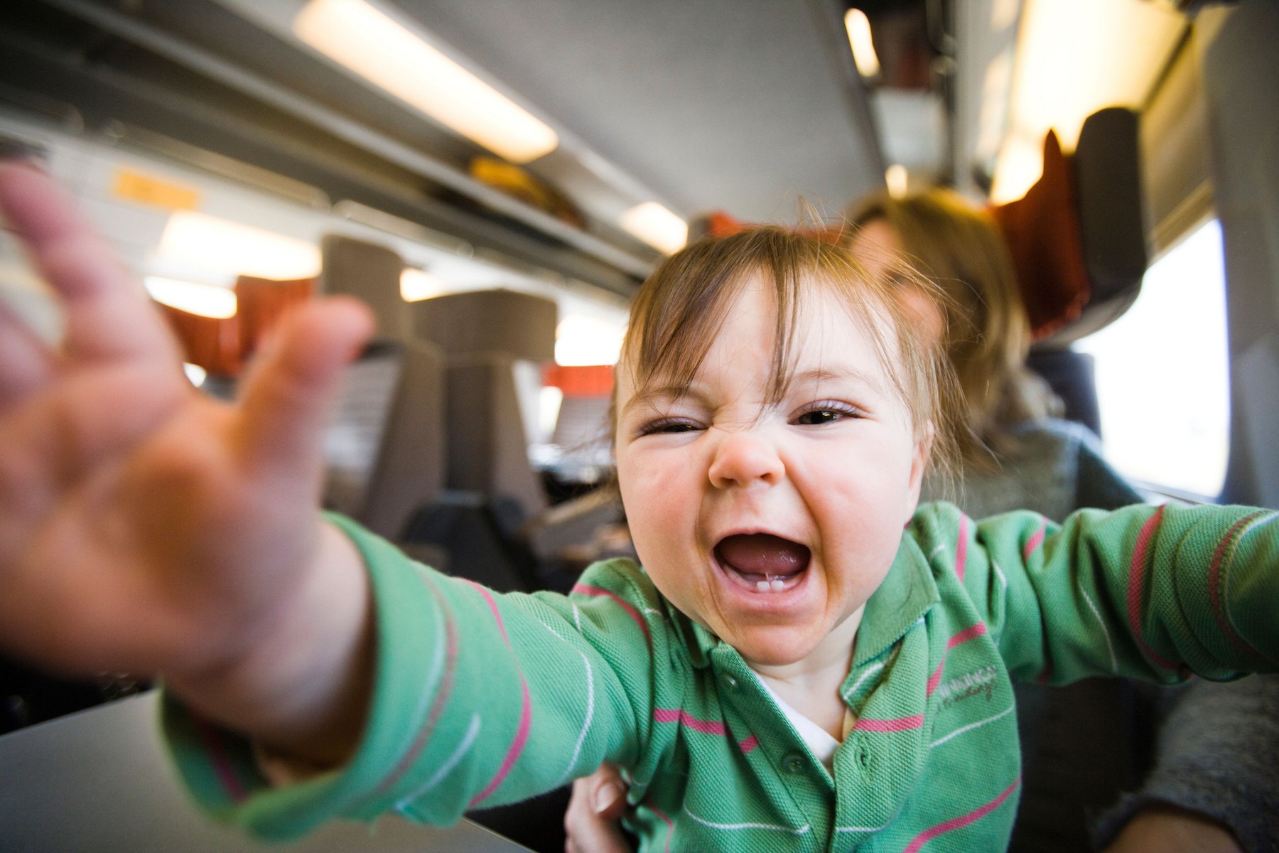 9 month old baby girl sitting on mother's lap and shouting on the eurostar train. Leisure Select class carriage