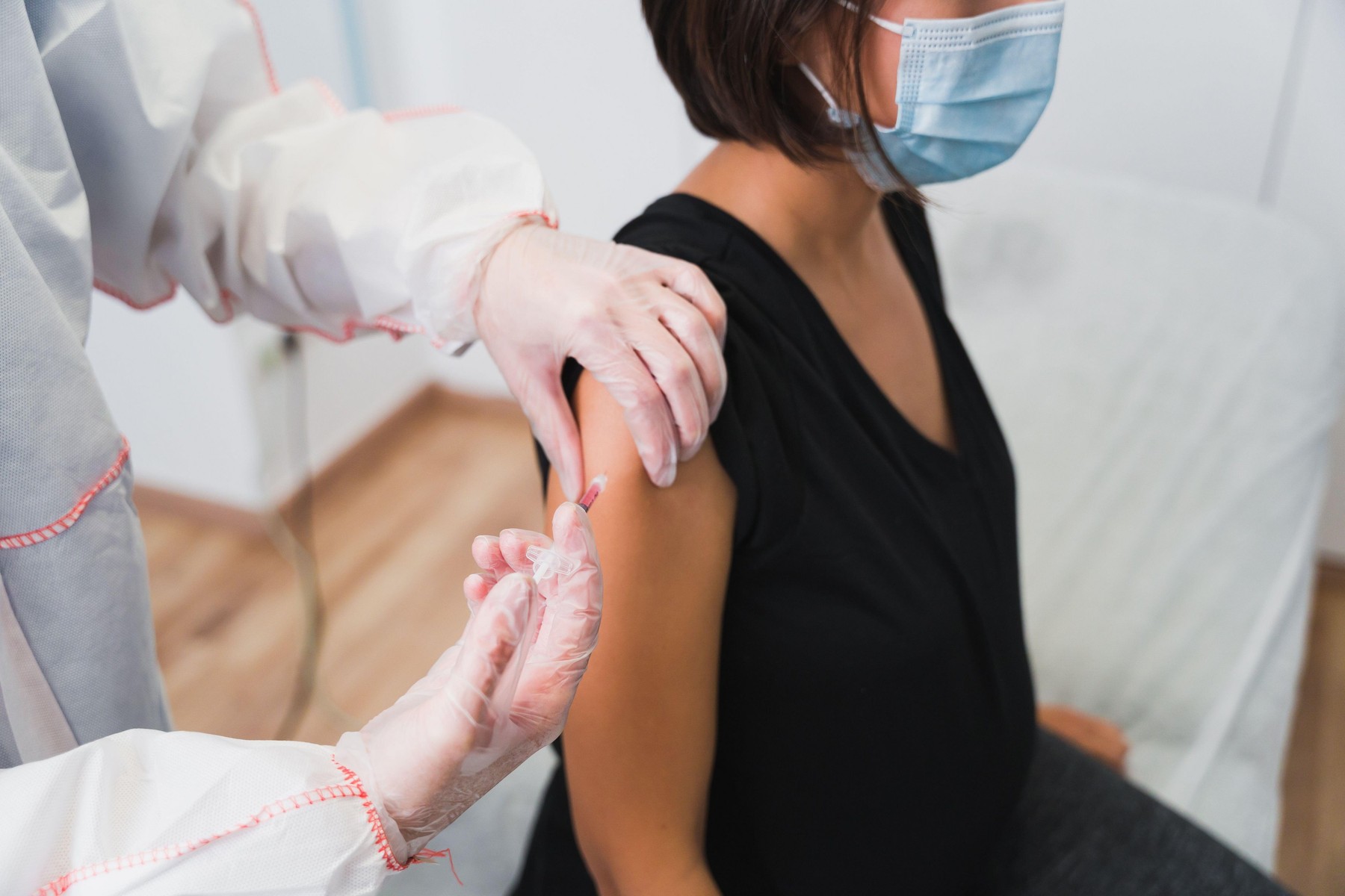 Doctor giving a vaccine to a pregnant woman against Covid 19 or flu or whooping cough.