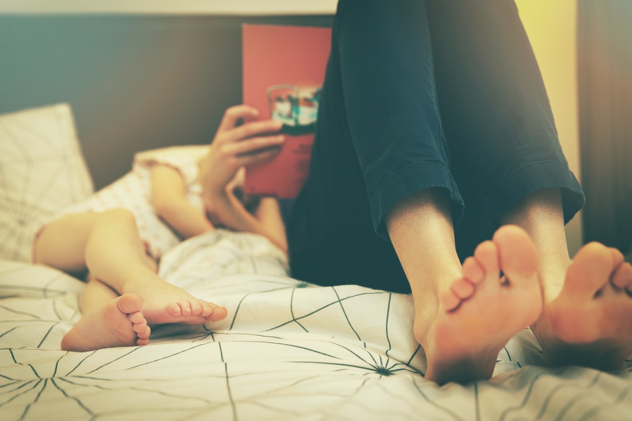 mother reading fairy book to her child in the evening before sleep at home
