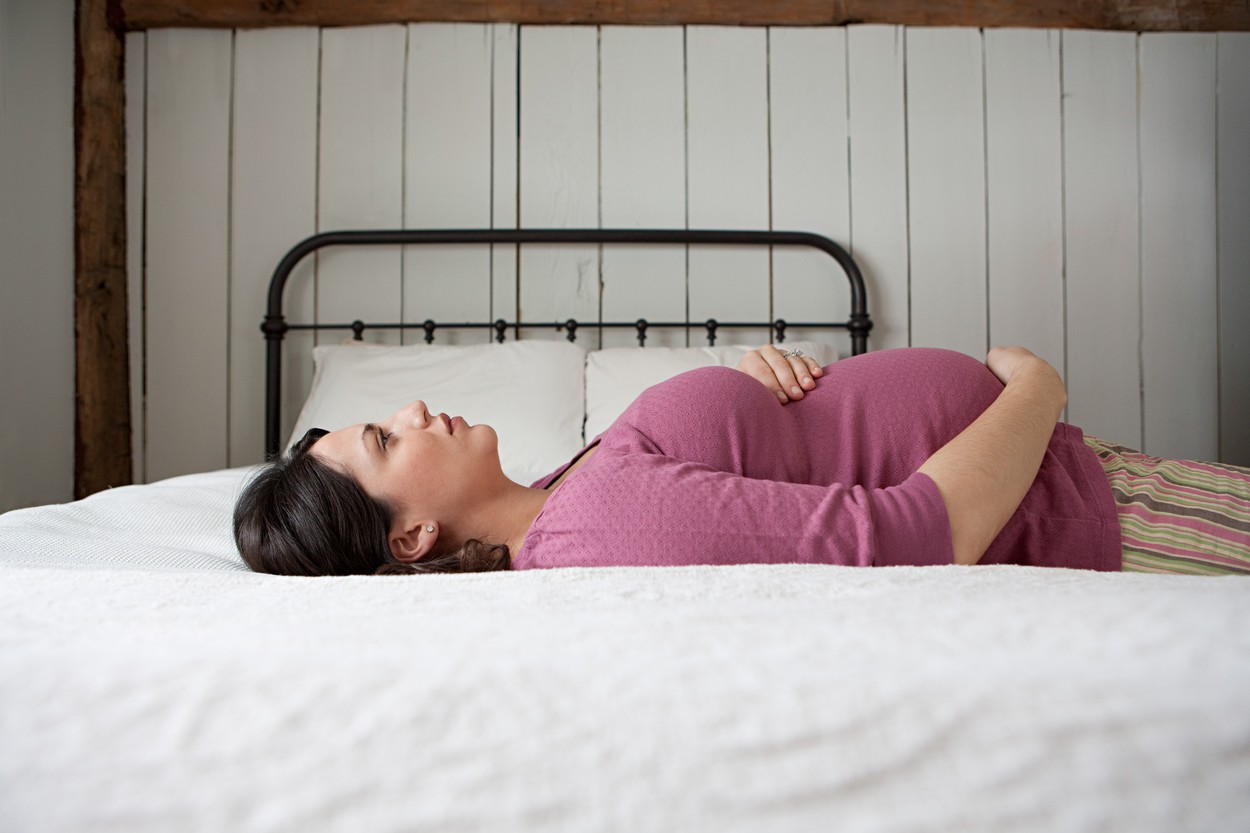 Pregnant woman lying on bed