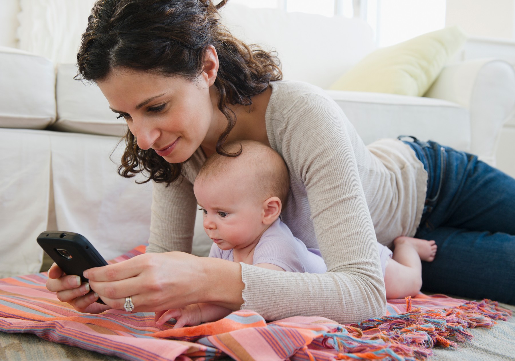 Mother with baby boy (2-5 months) text messaging
