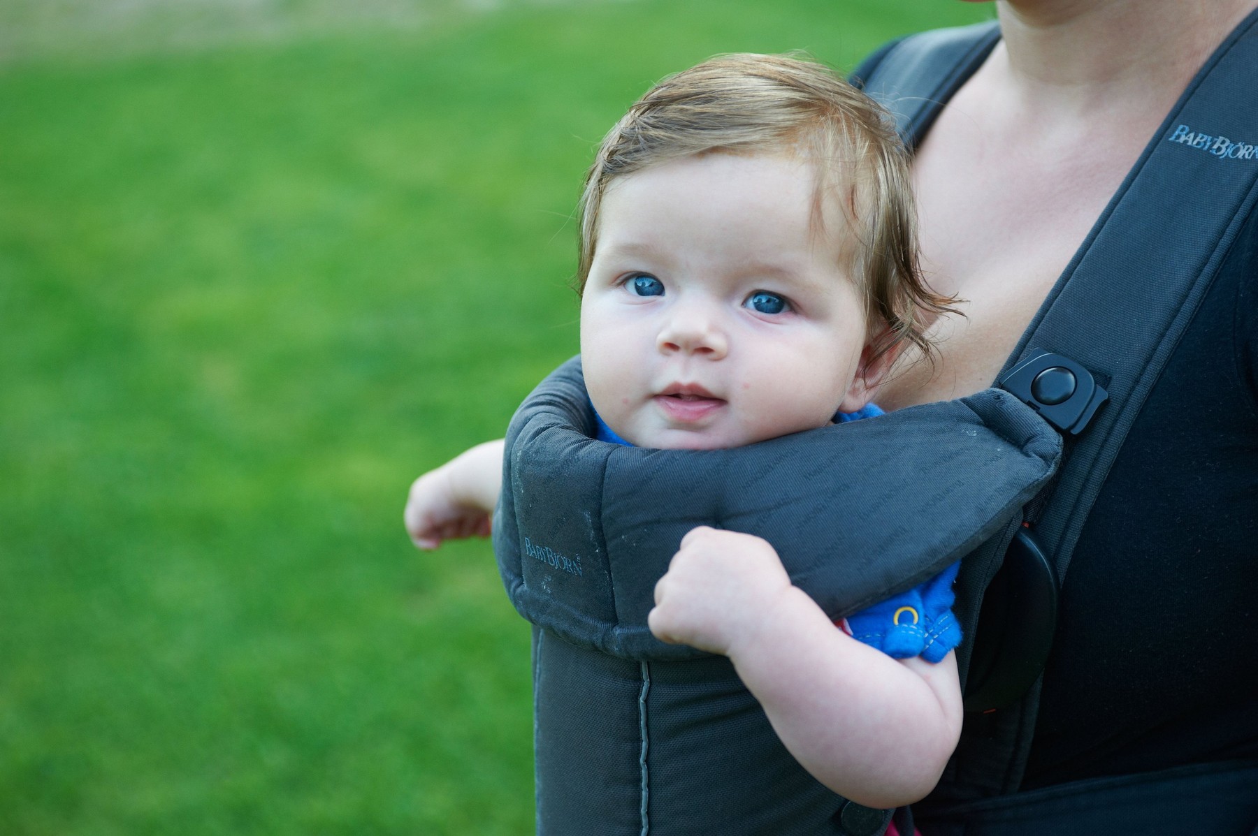 Mother carrying baby in baby carrier outside