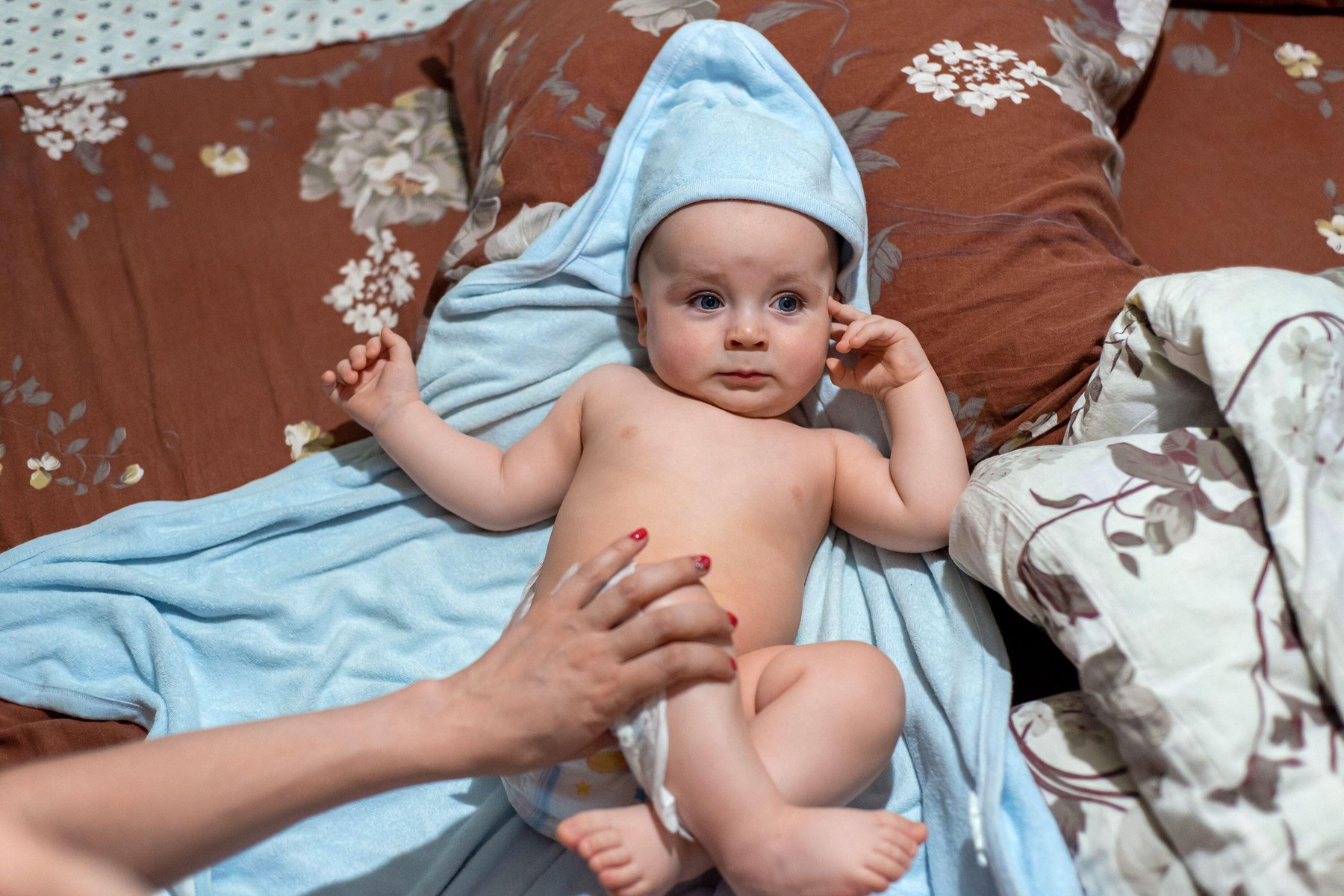 Mother changes the diaper of her baby infant. Mom dresses a newborn baby in the bedroom. Replacement, dressing a diaper.