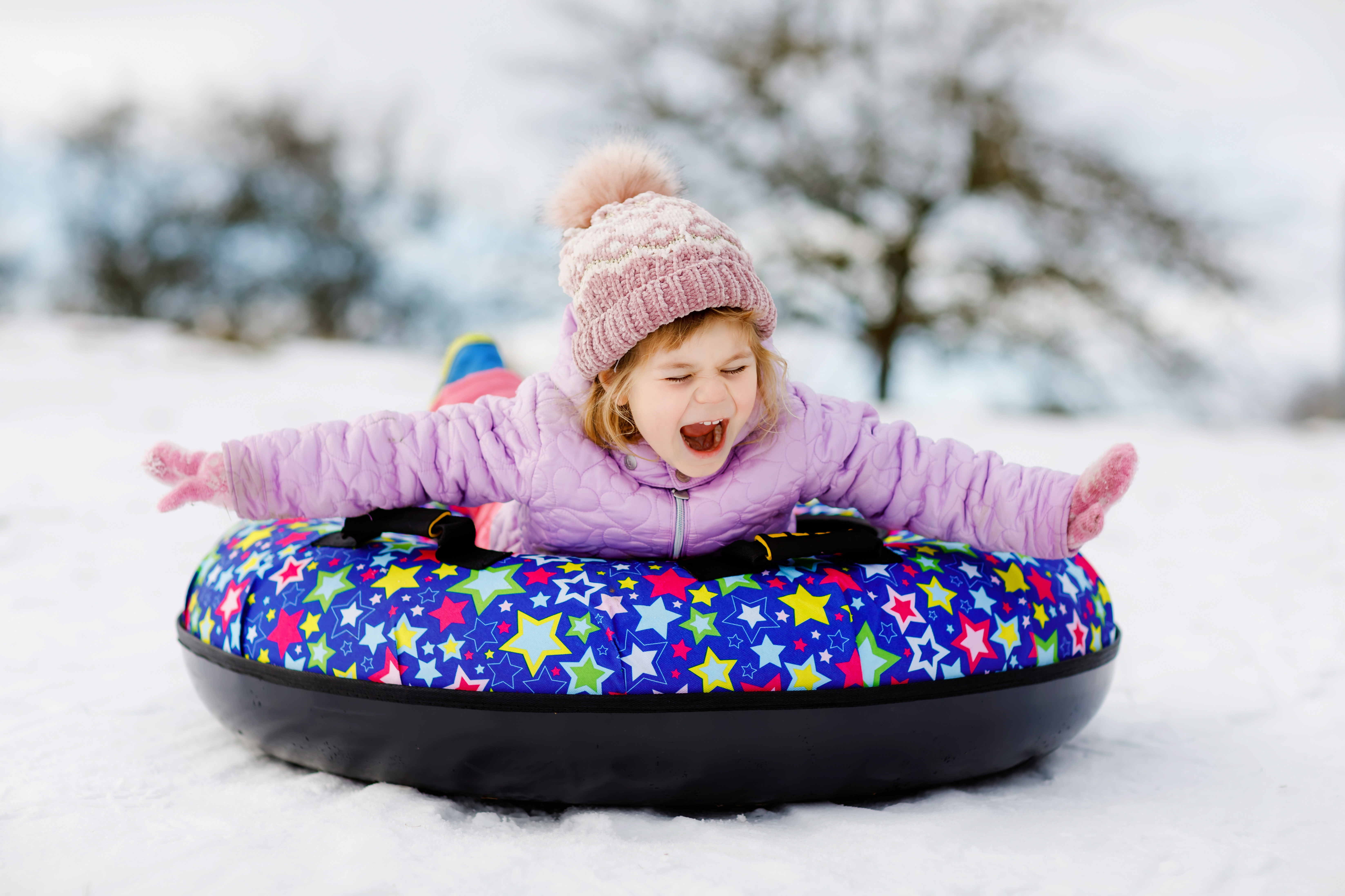 Active,Toddler,Girl,Sliding,Down,The,Hill,On,Snow,Tube.