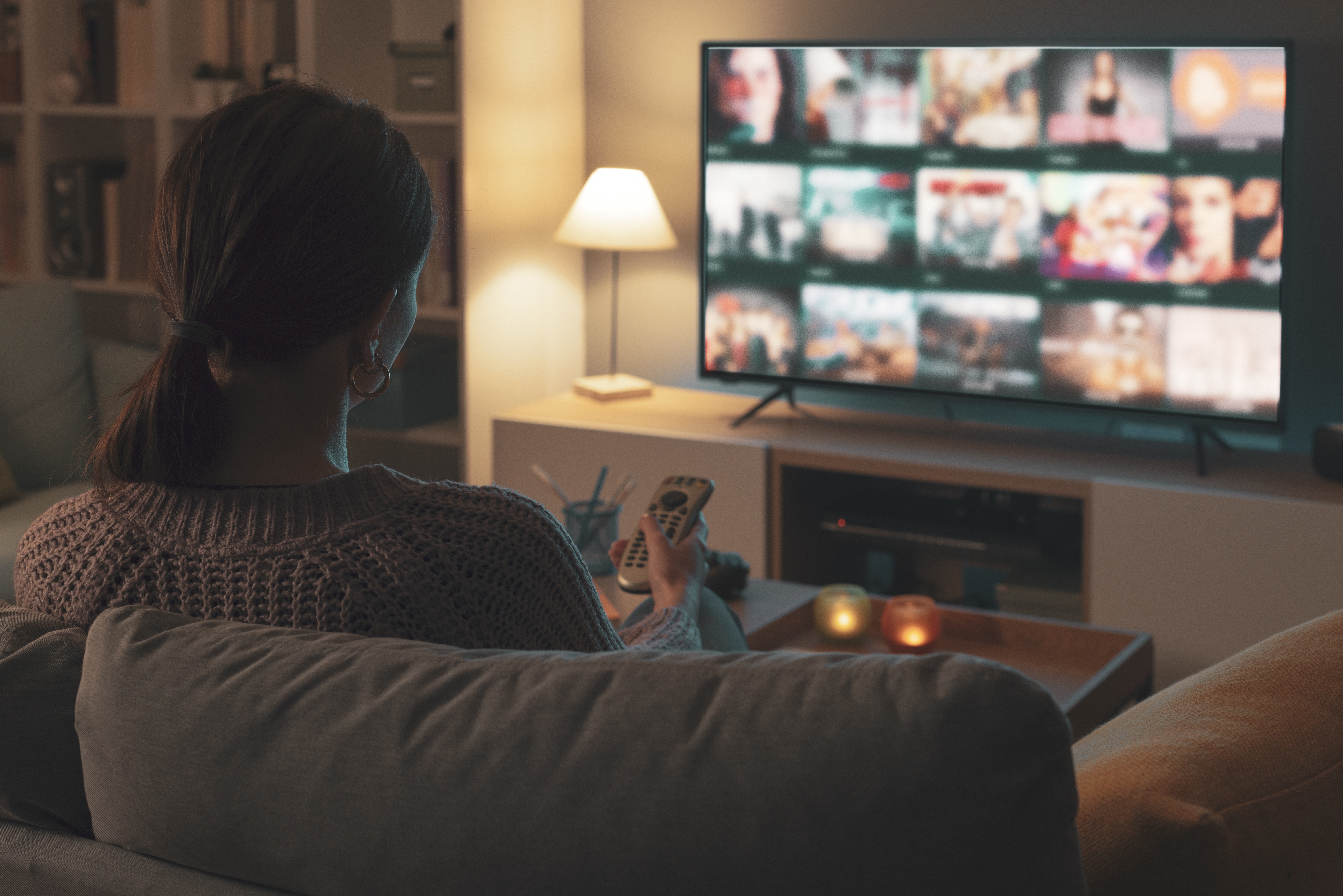 Woman,Relaxing,On,The,Couch,,She,Is,Using,The,Remote