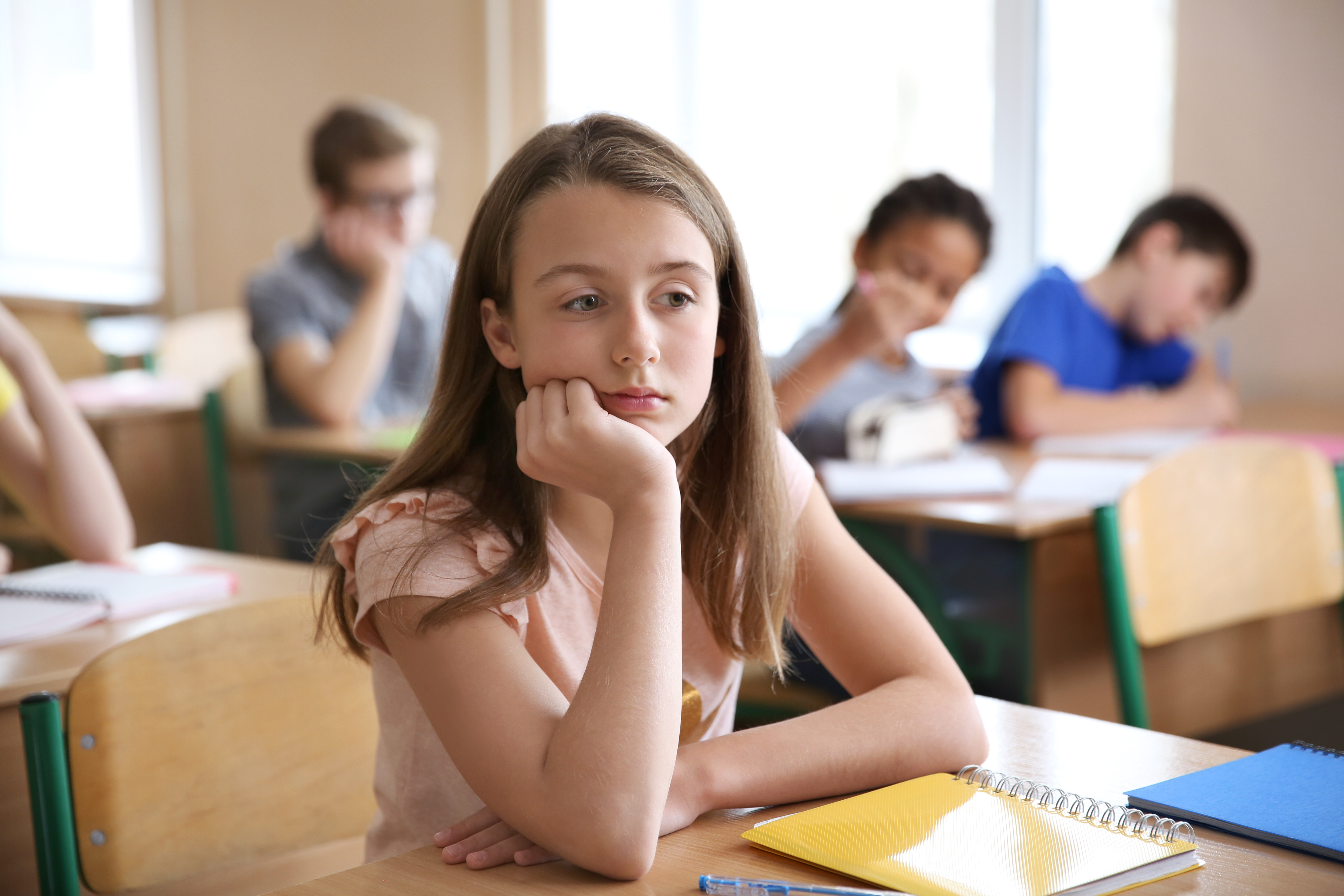 Sad,Girl,Sitting,In,Classroom.,Bullying,At,School