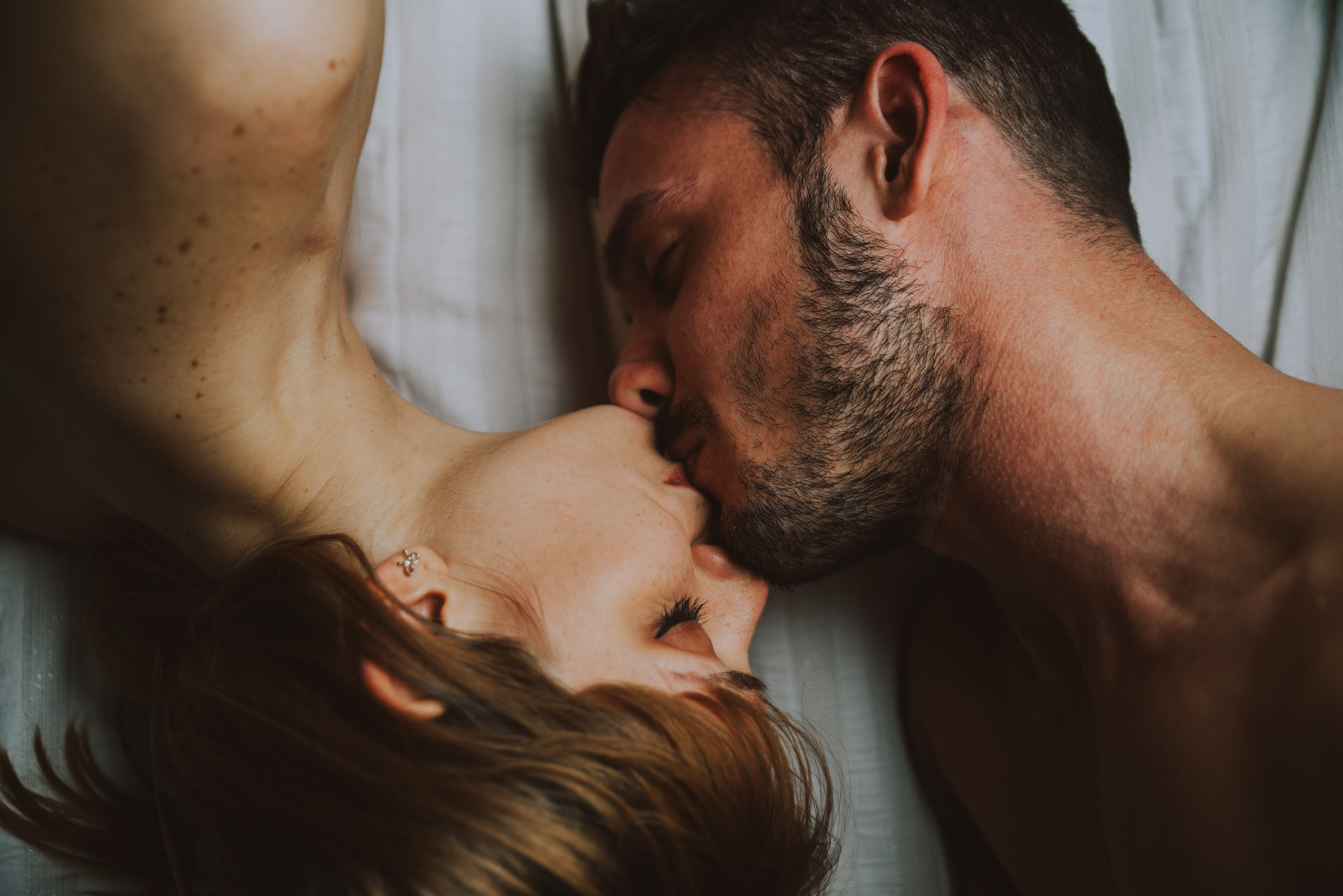 Young,Couple,Relaxing,In,Bed,And,Having,Fun.,Kissing,After