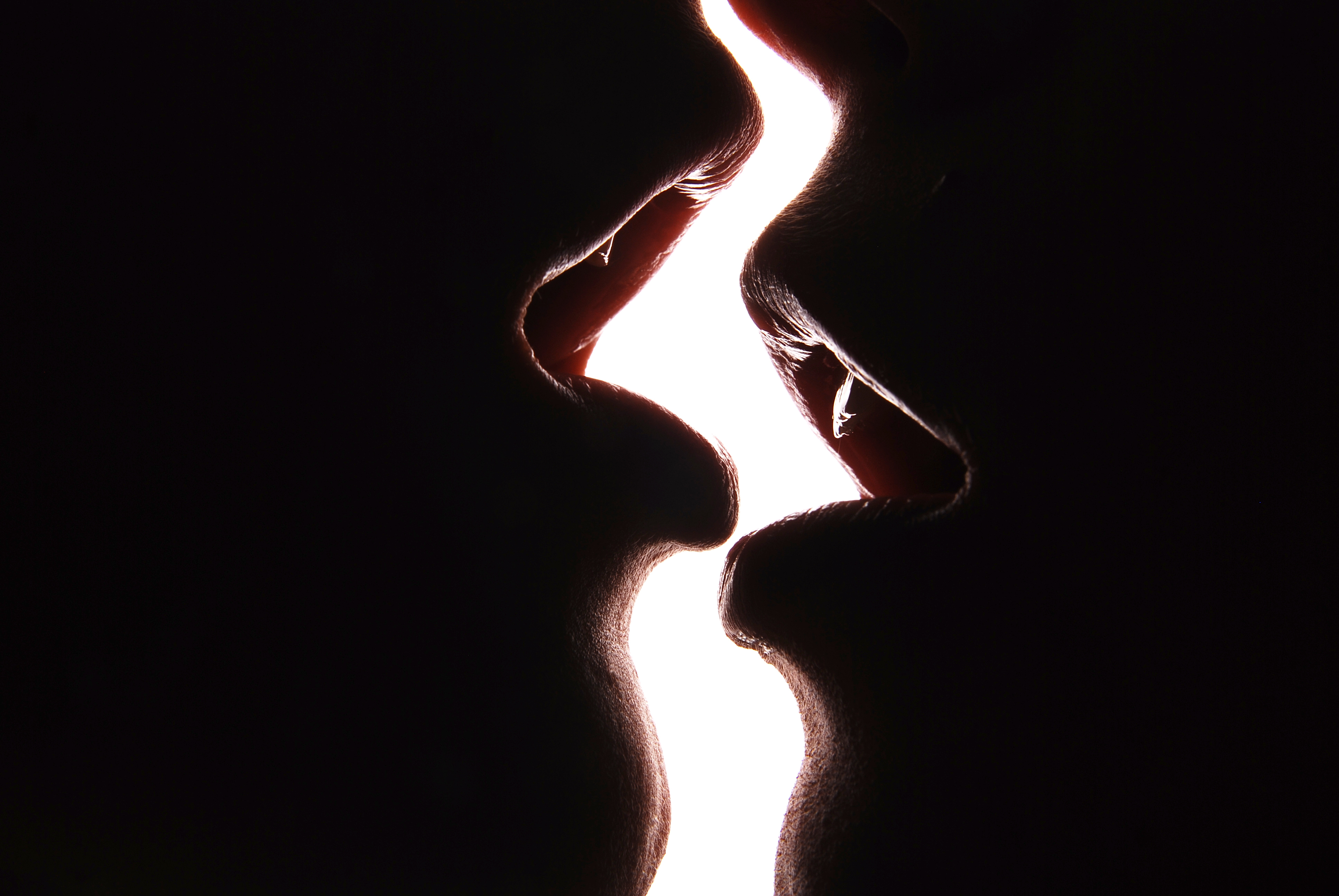 Two,Girls,Kissing,In,Front,Of,A,White,Wall.