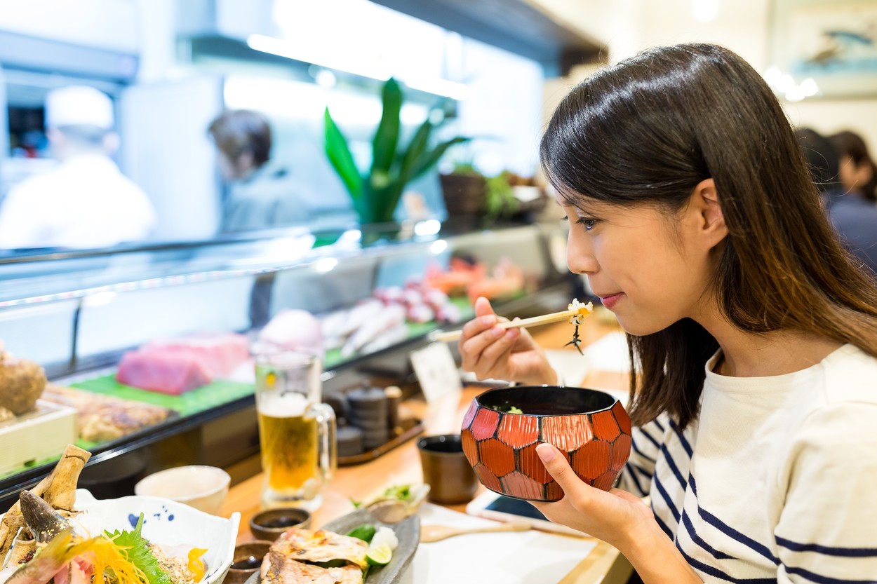 Woman eating rice in japanese restaurant