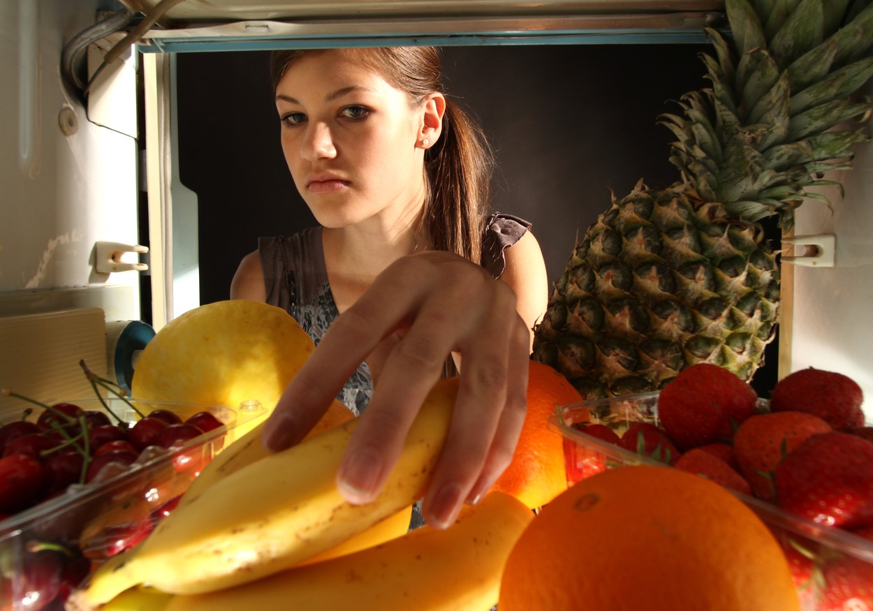 girl gets bananas from the refrigerator