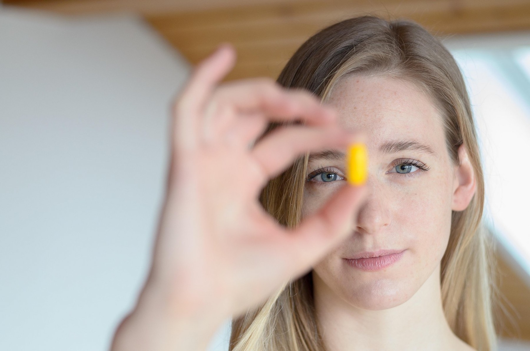Portrait of young blond woman holding medical tablet in hand, focus on face