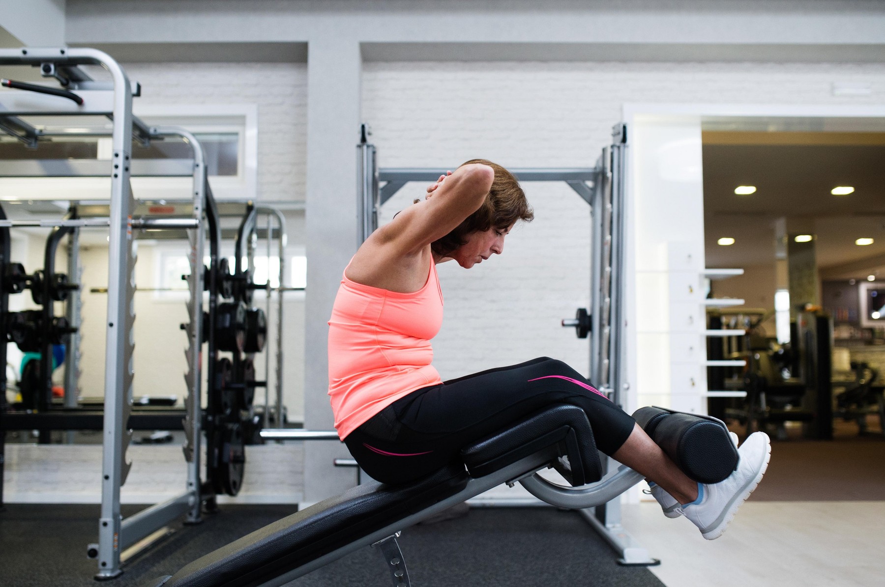 Beautiful fit senior woman working her abs, doing crunches.