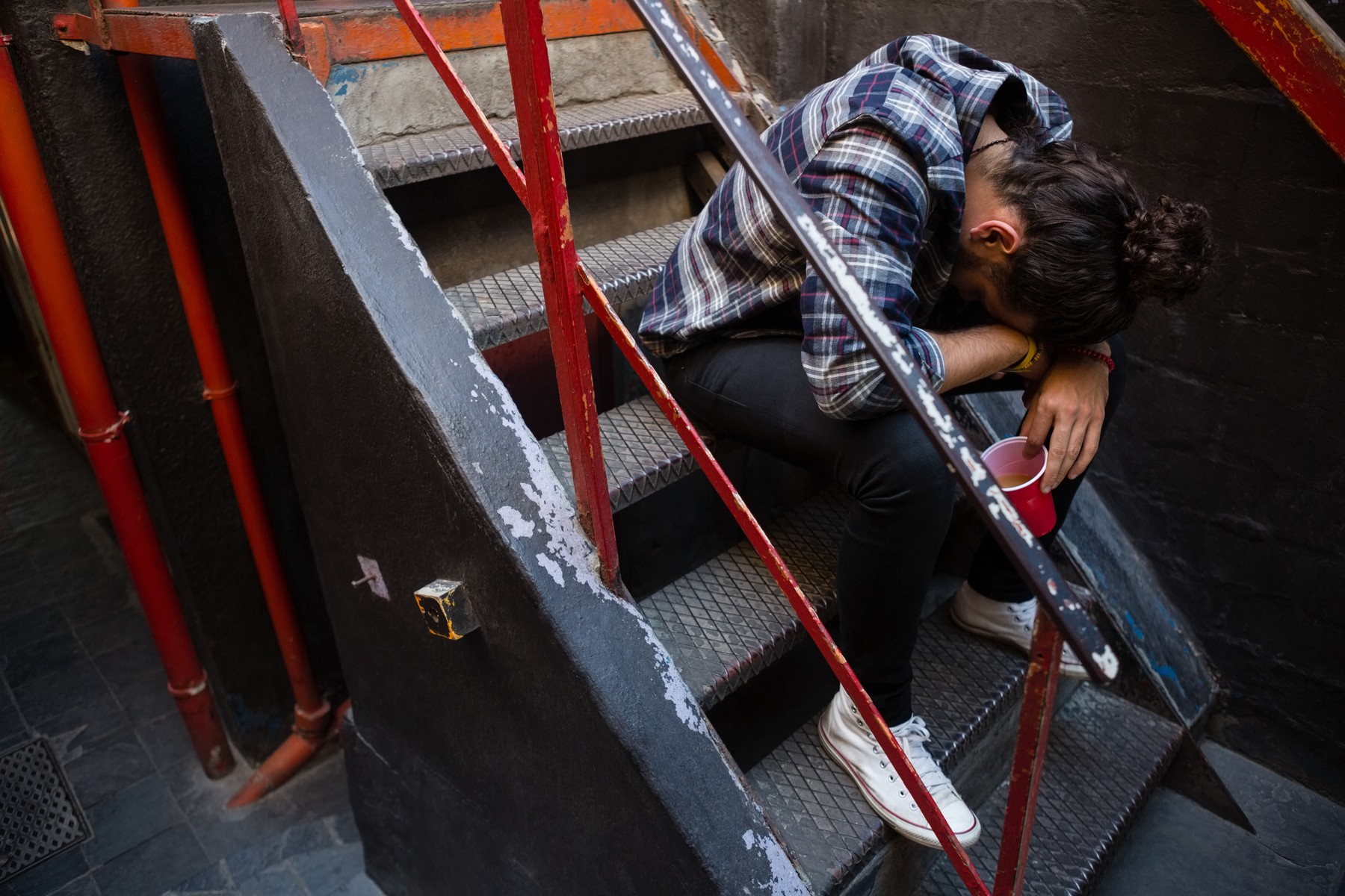 Drunk man sitting on staircase
