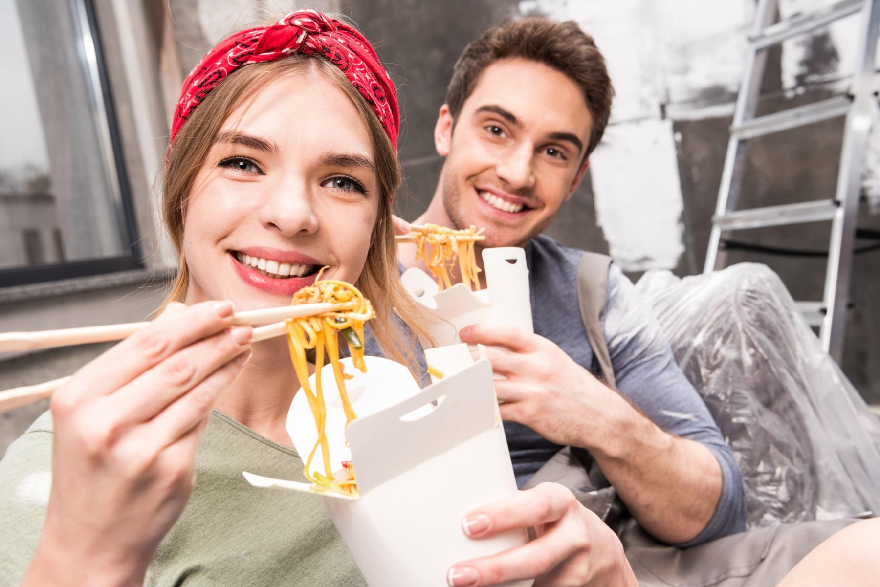 couple eating thai food while resting during renovation home process