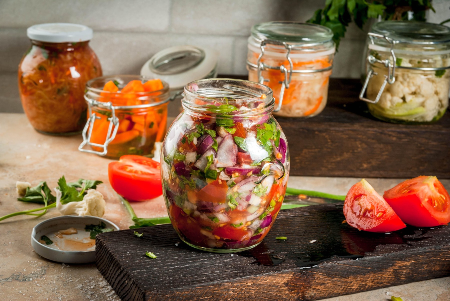 Concept of a fermented meal. Home canned food and billets. Vegan food. Vegetables. Cans of canned salsa, sauerkraut, marinated carrots, kimchi and cau