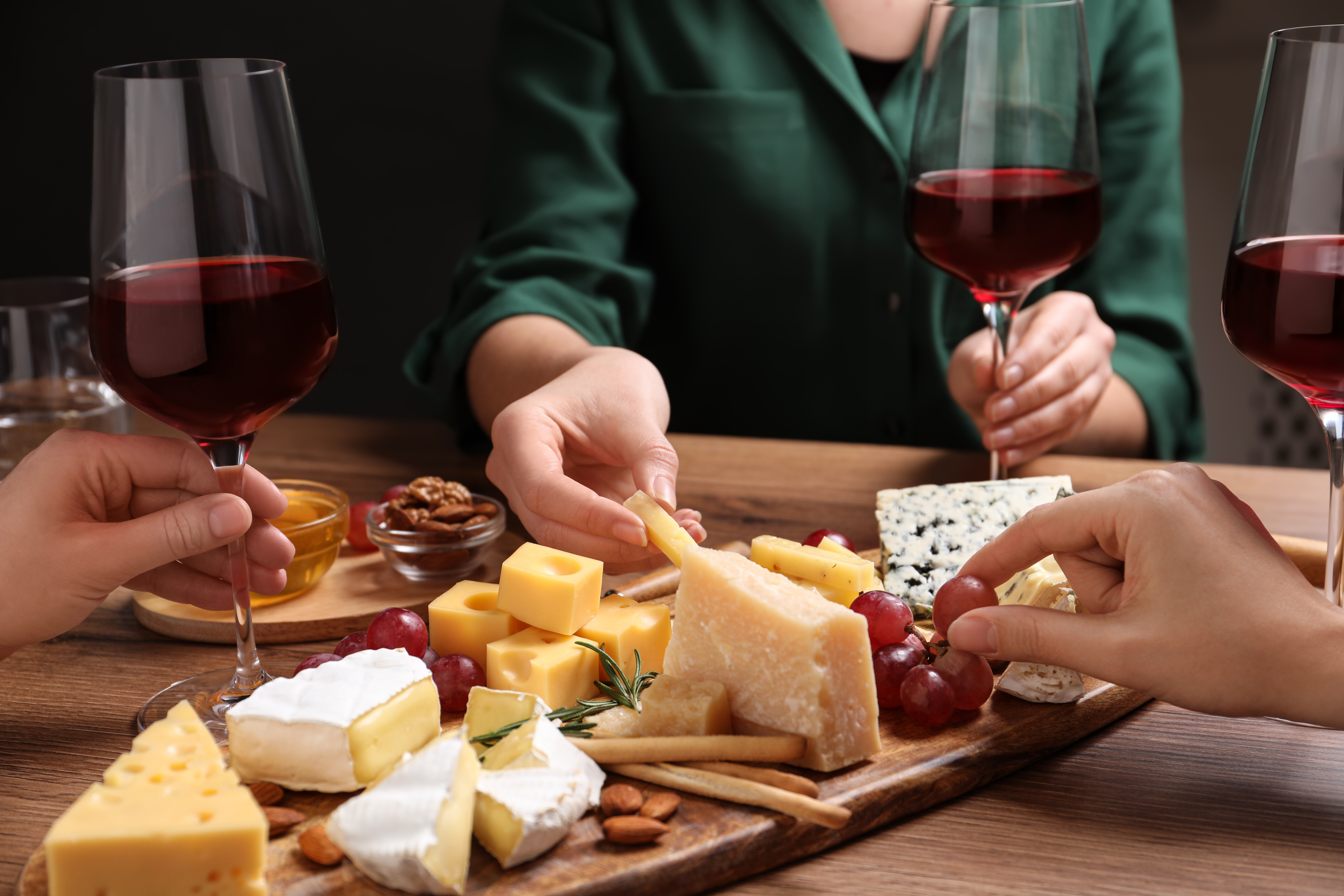Women,With,Cheese,Plate,And,Glasses,Of,Wine,At,Wooden