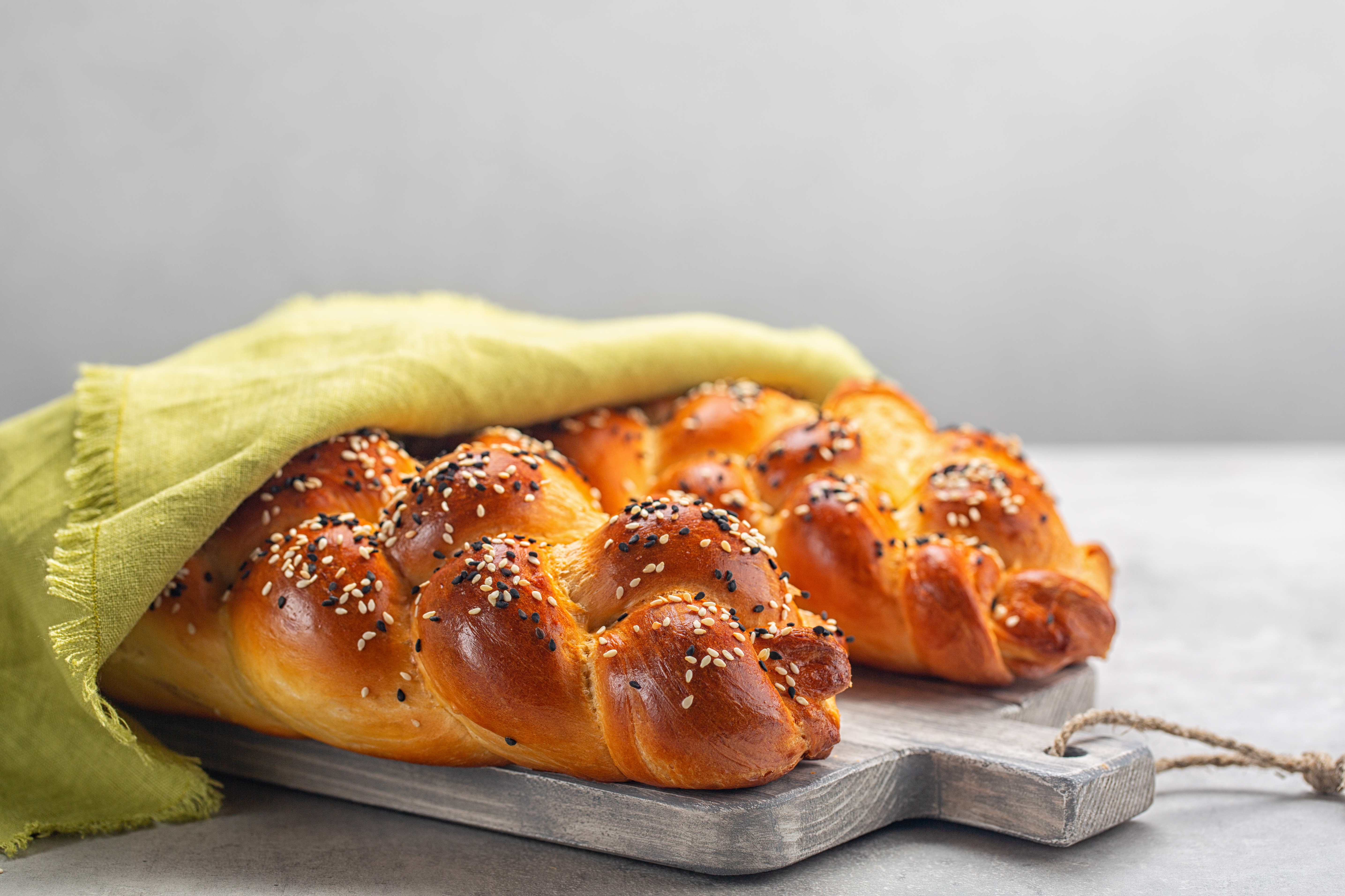Two,Loaves,Of,Homemade,Challah,Bread,With,Green,Cover.,Selective