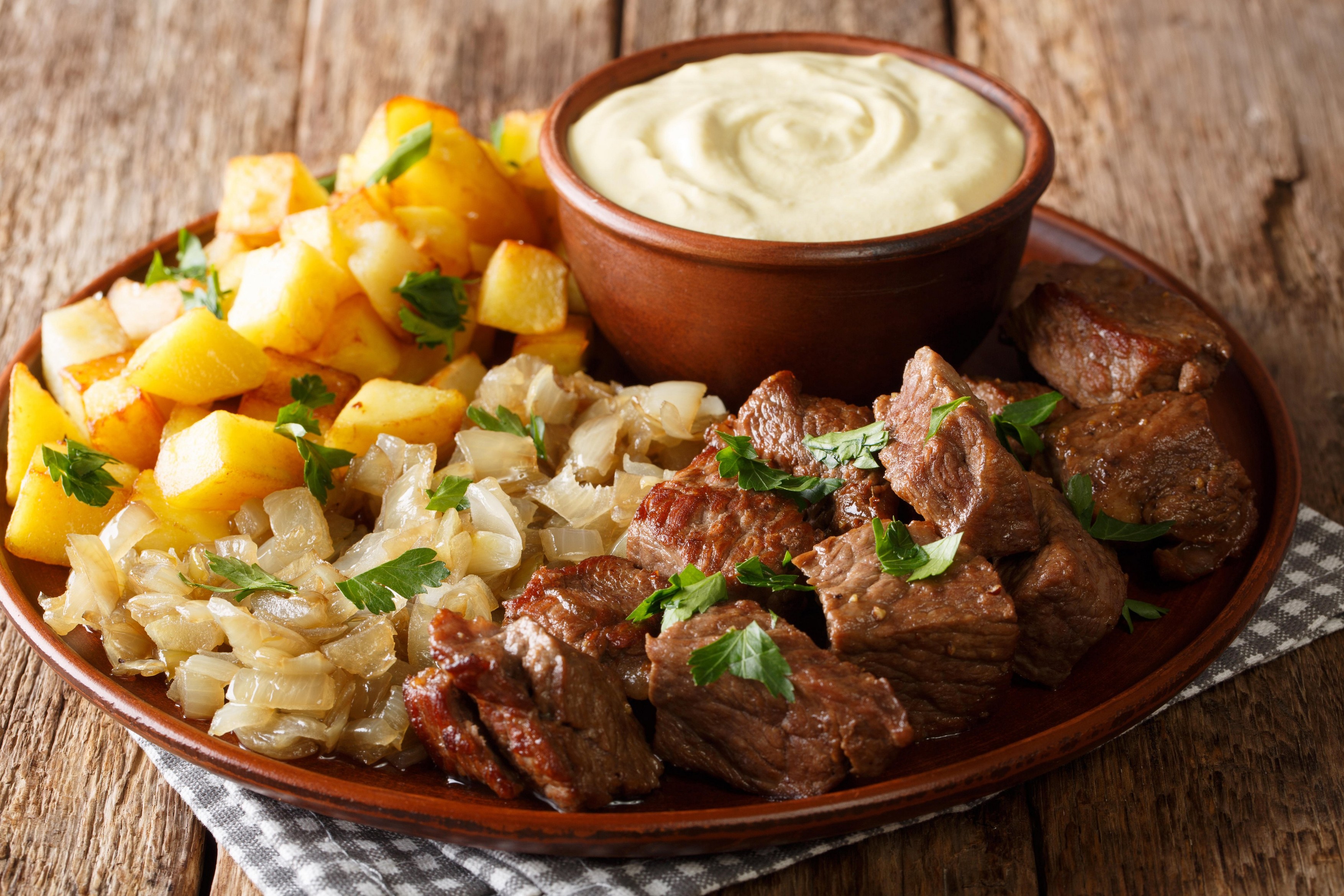 Beef Rydberg with crisp potatoes and beef tenderloin with onion marmalade close-up on a plate on the table. Horizontal
