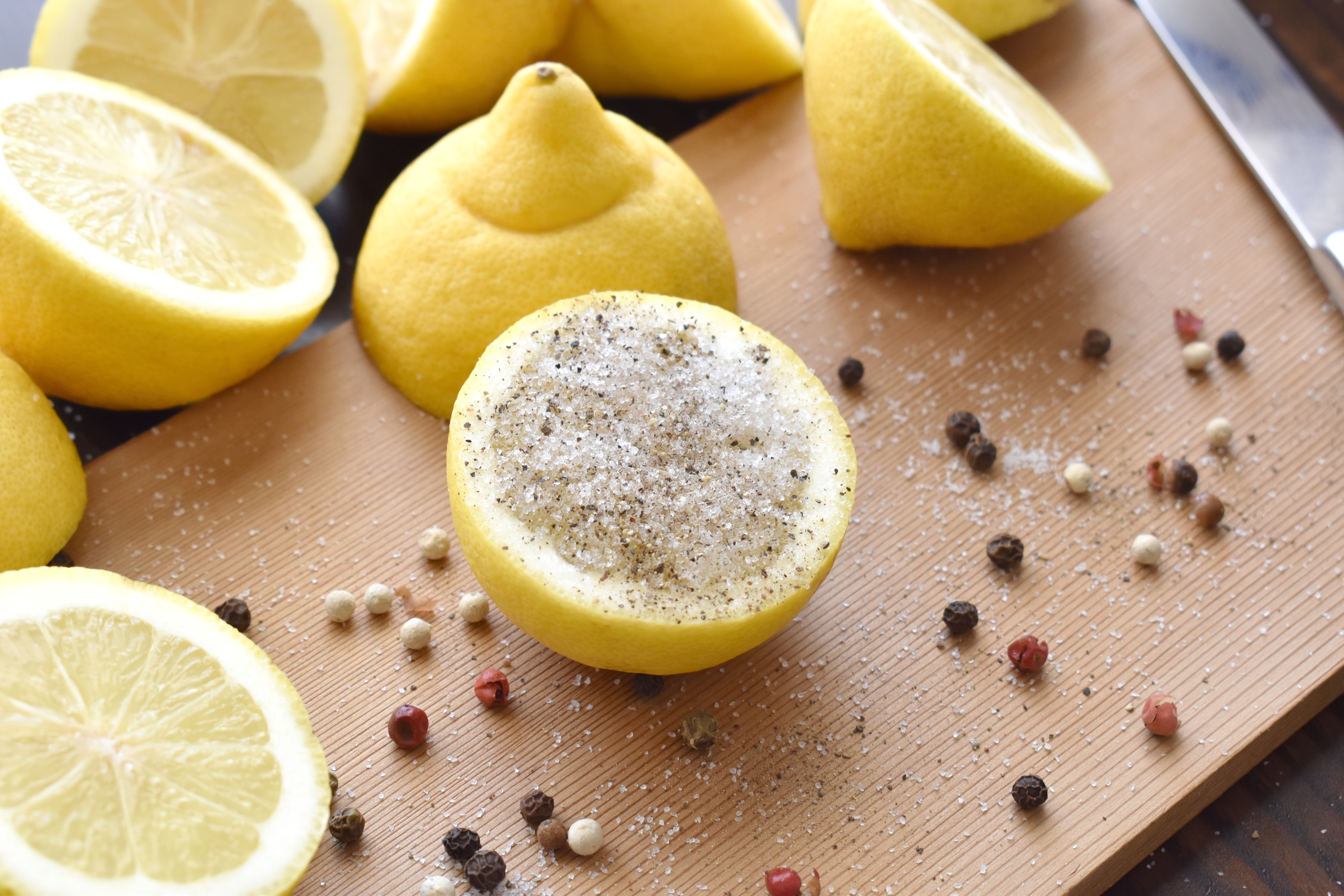 Lemon,With,Salt,And,Pepper,On,A,Bamboo,Chopping,Board.