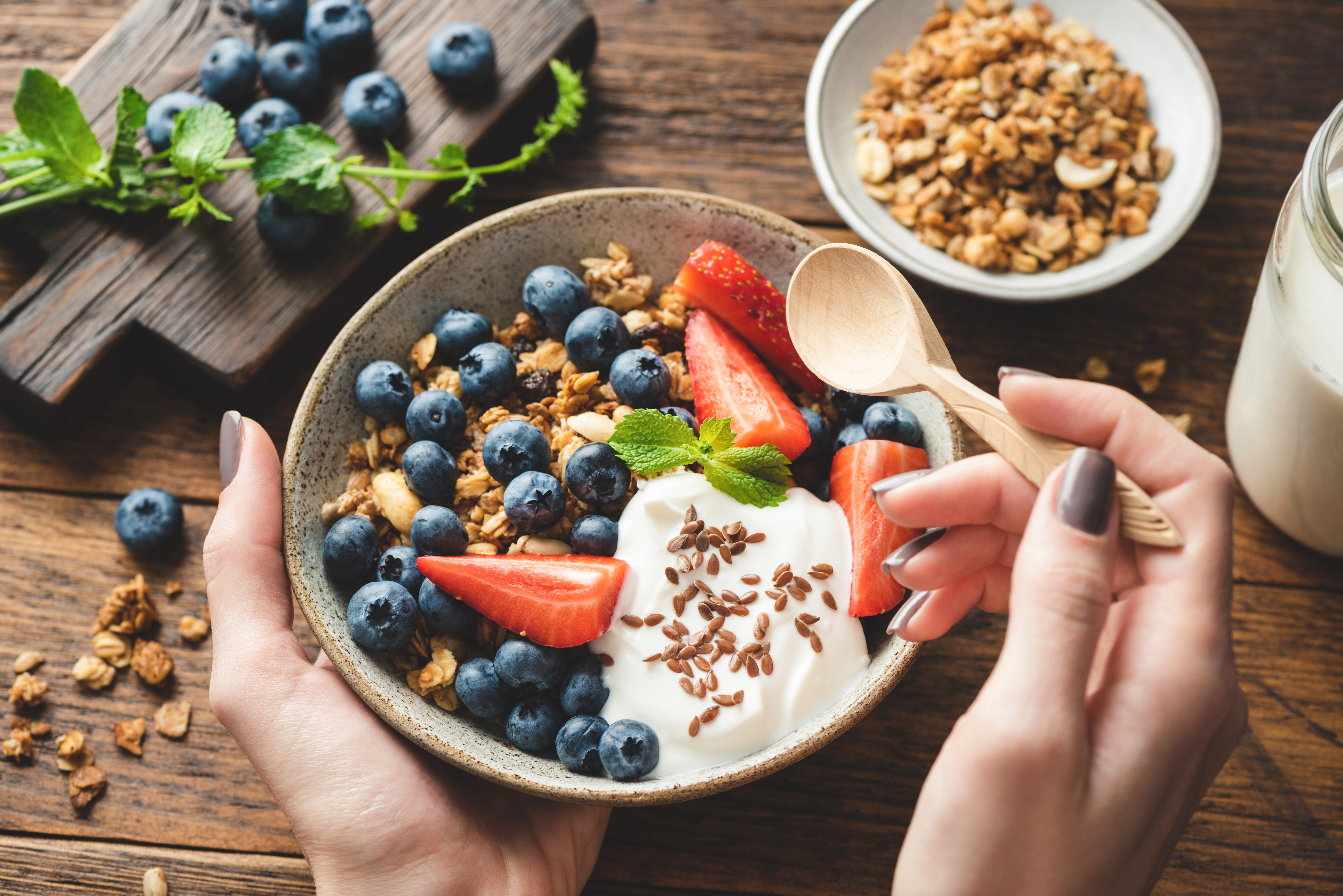 Eating,Granola,With,Greek,Yogurt,And,Berries.,Female,Hands,Holding