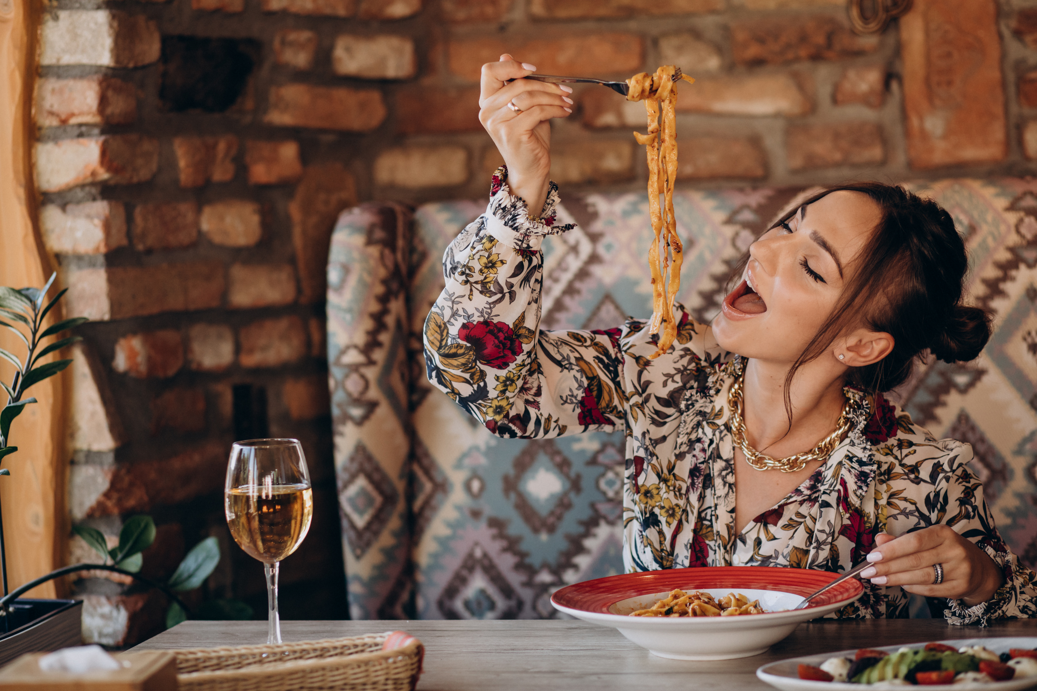 Woman,Eating,Pasta,In,An,Italian,Restaurant