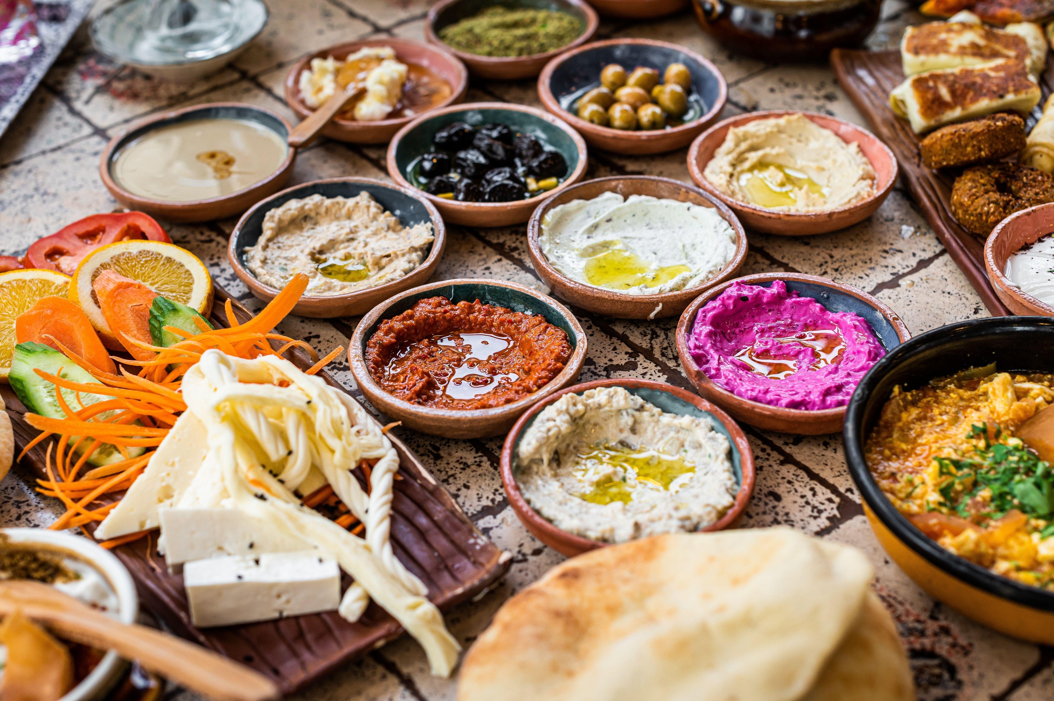 Delicious Turkish family breakfast table with pastries, vegetables, greens, spreads, cheeses, fried eggs, jams. Top view