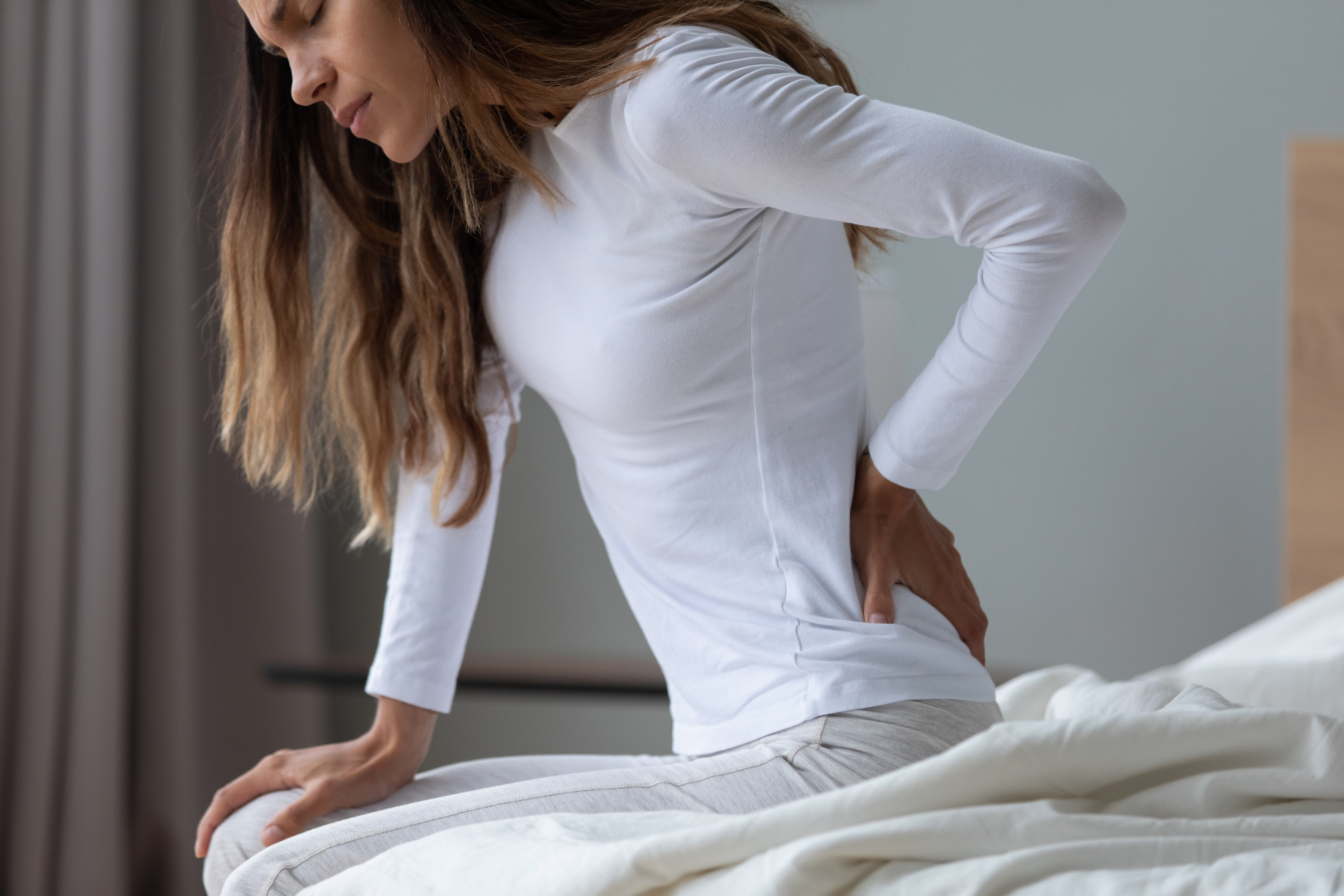 Close,Up,Unhappy,Woman,Wearing,Pajama,Rubbing,Stiff,Back,Muscles
