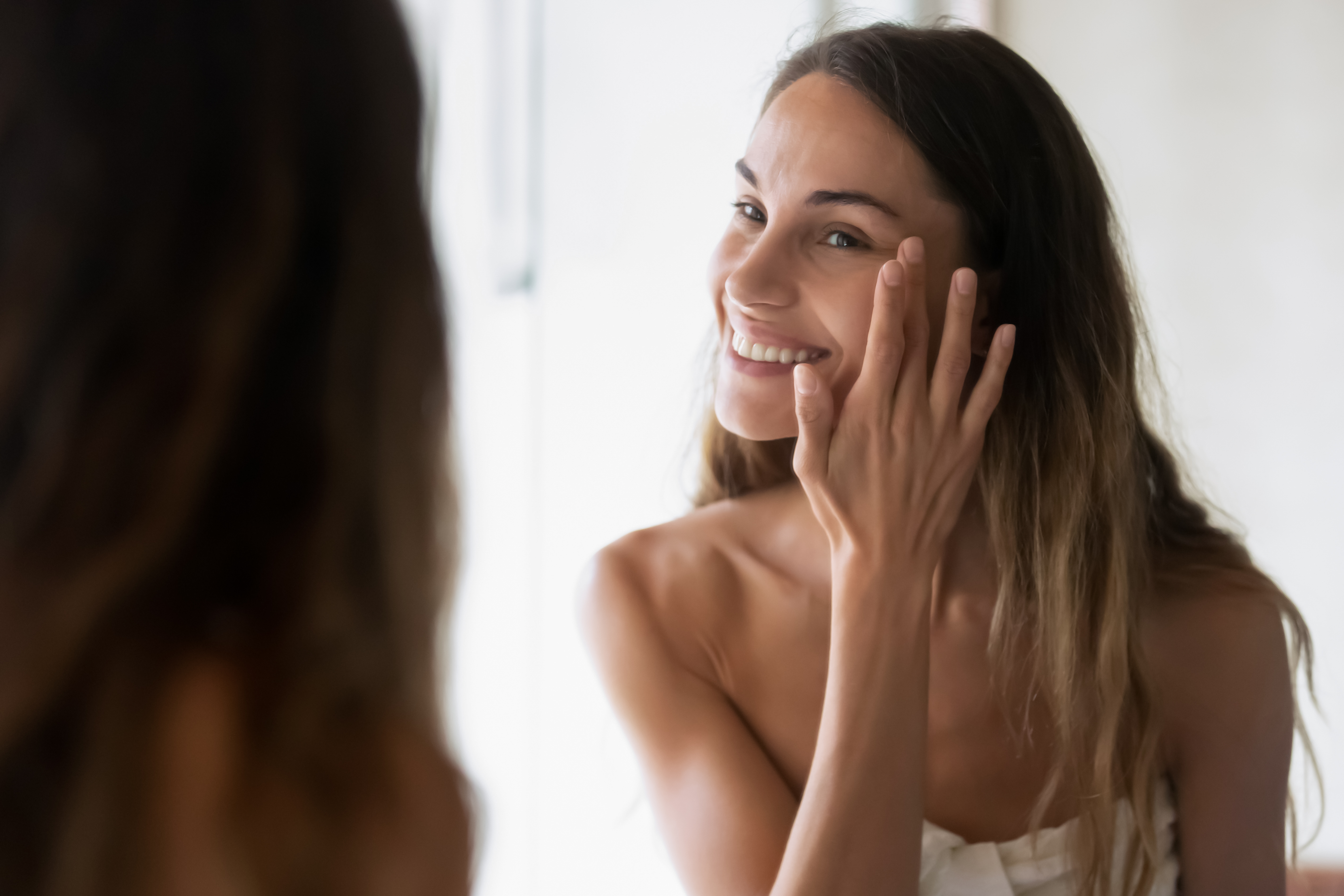 Smiling,Girl,In,Bath,Towel,Look,In,Mirror,Apply,Moisturizing