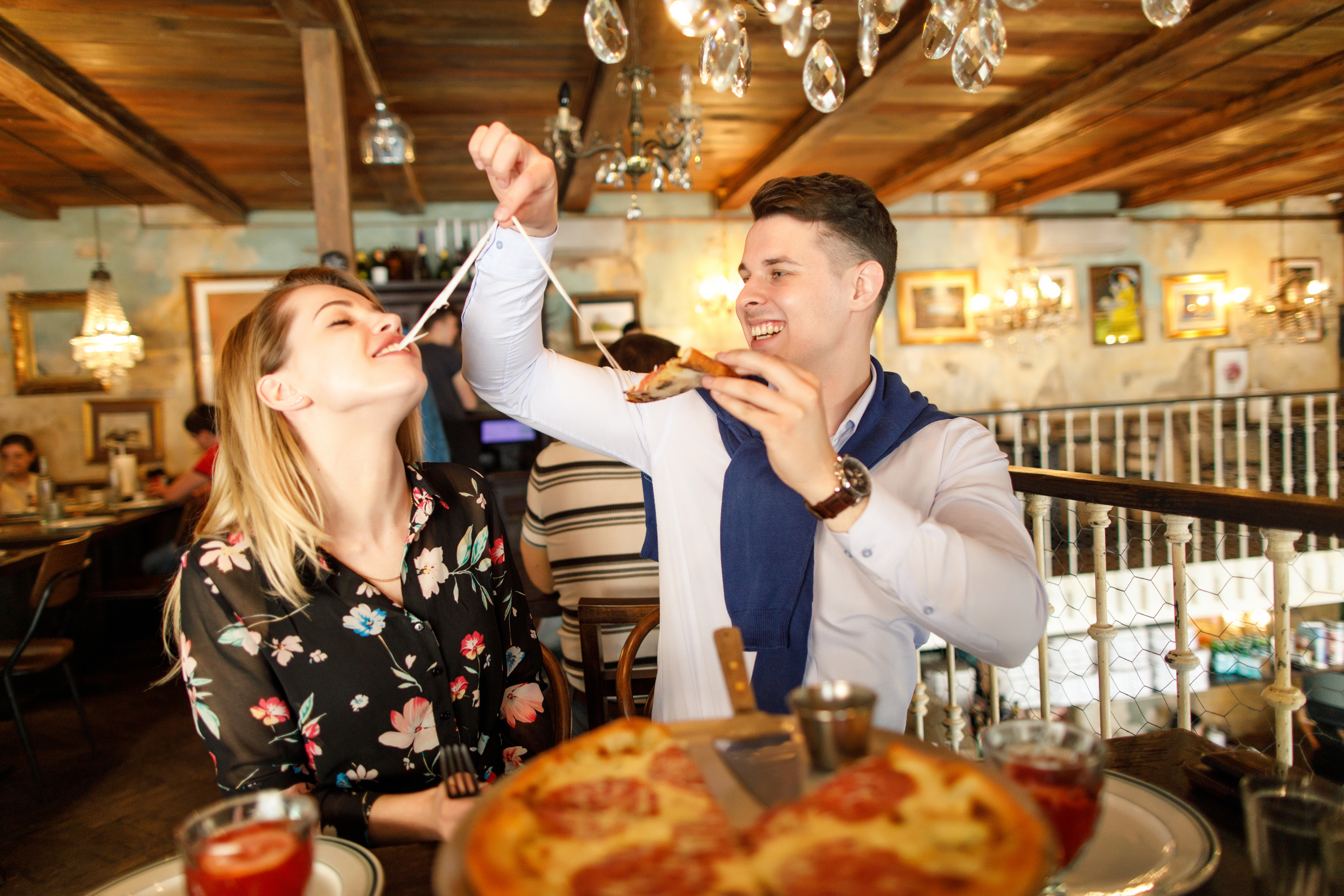 Young,Beautiful,Couple,Eating,Pizza,In,A,Restaurant