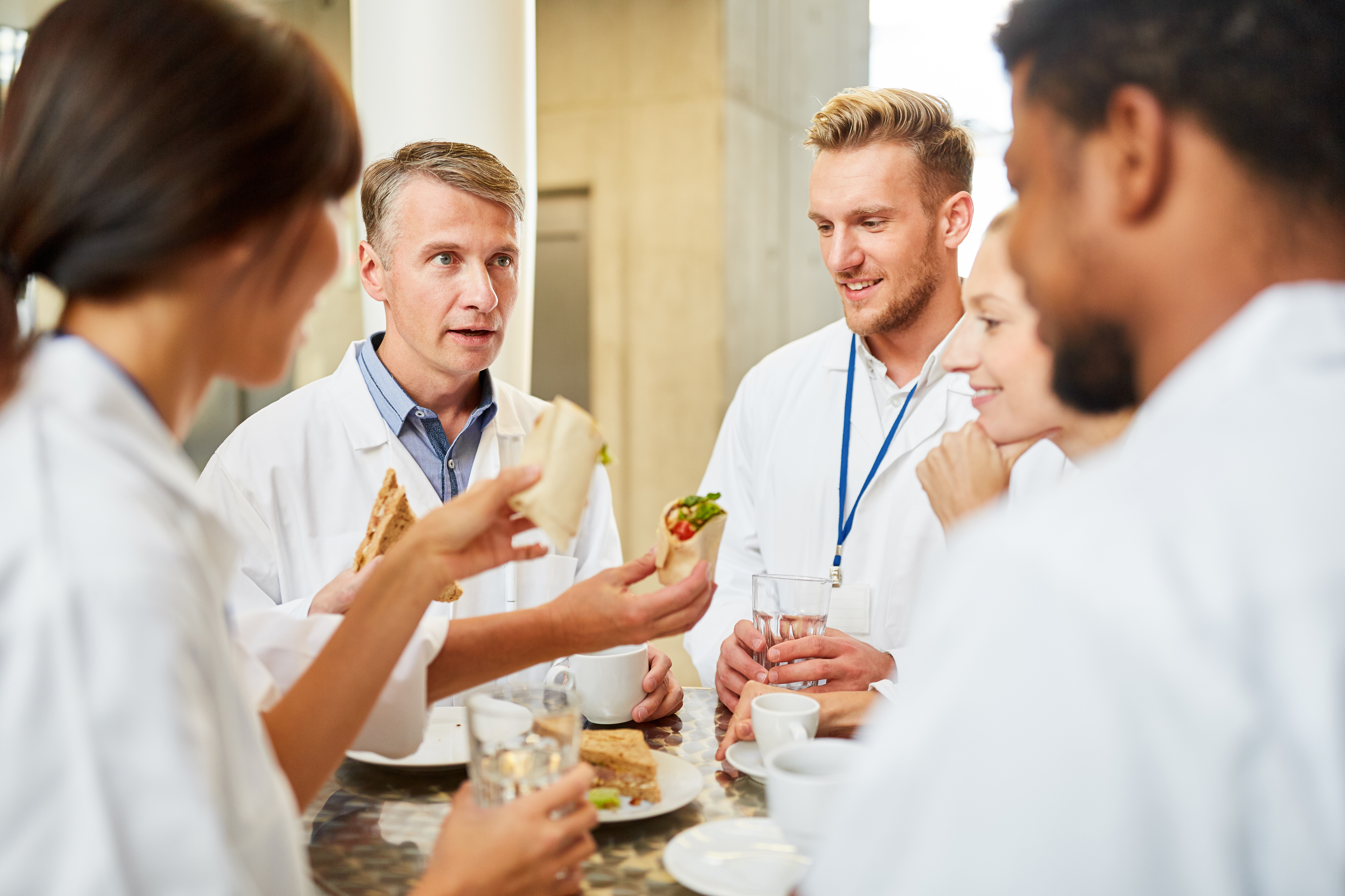 Group,Of,Doctors,In,The,Cafeteria,Or,Canteen,Eating,And