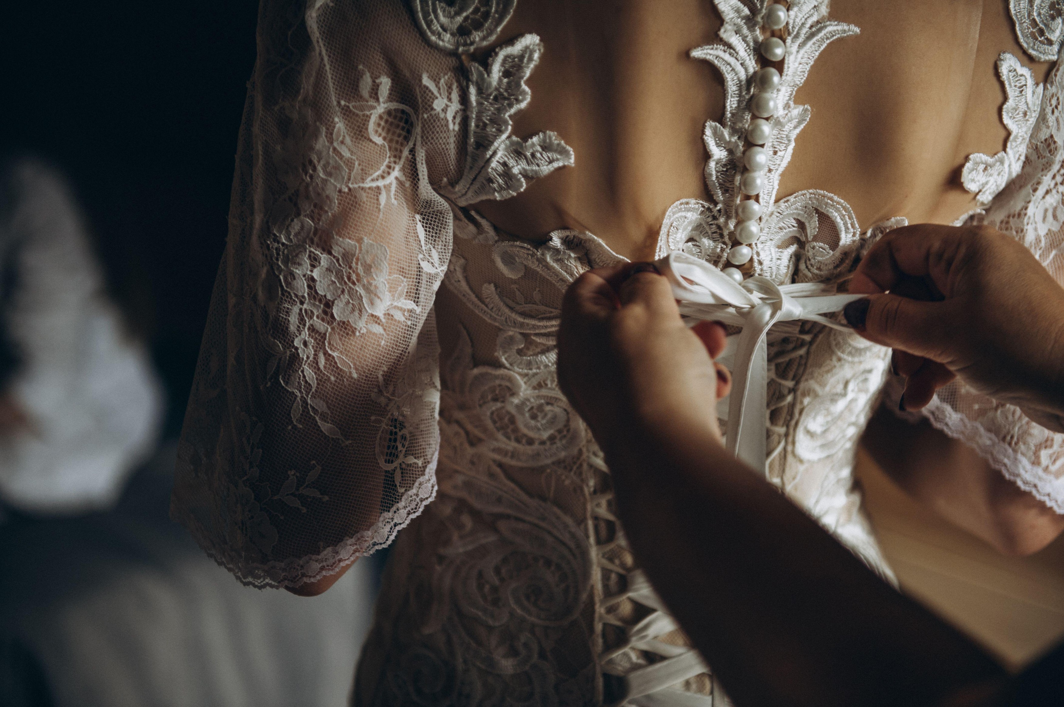 The bride's back in the wedding dress. Bride tied bow on the back of a wedding dress.
