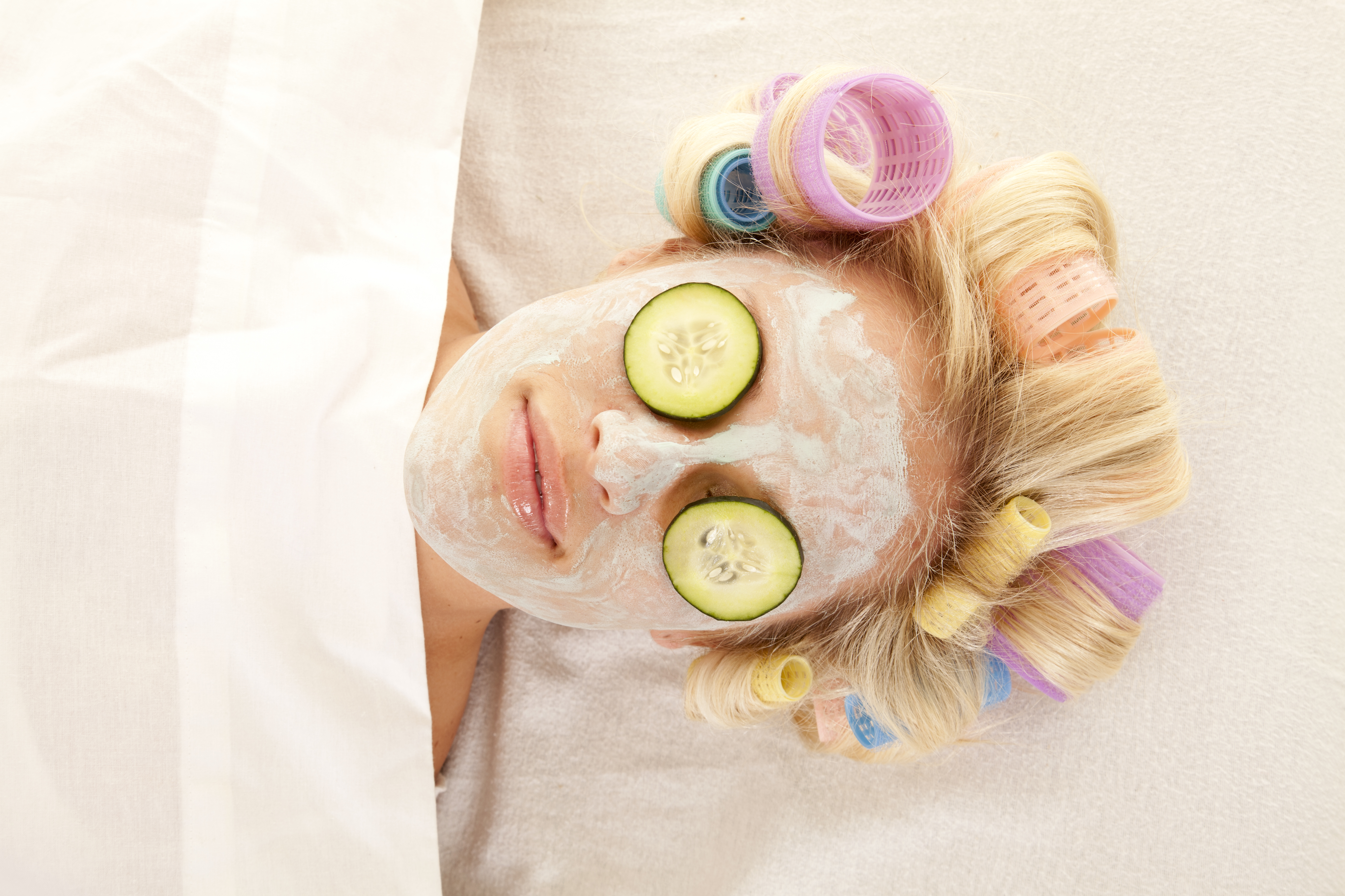 A,Woman,Is,Laying,With,Curlers,And,A,Cream,Face