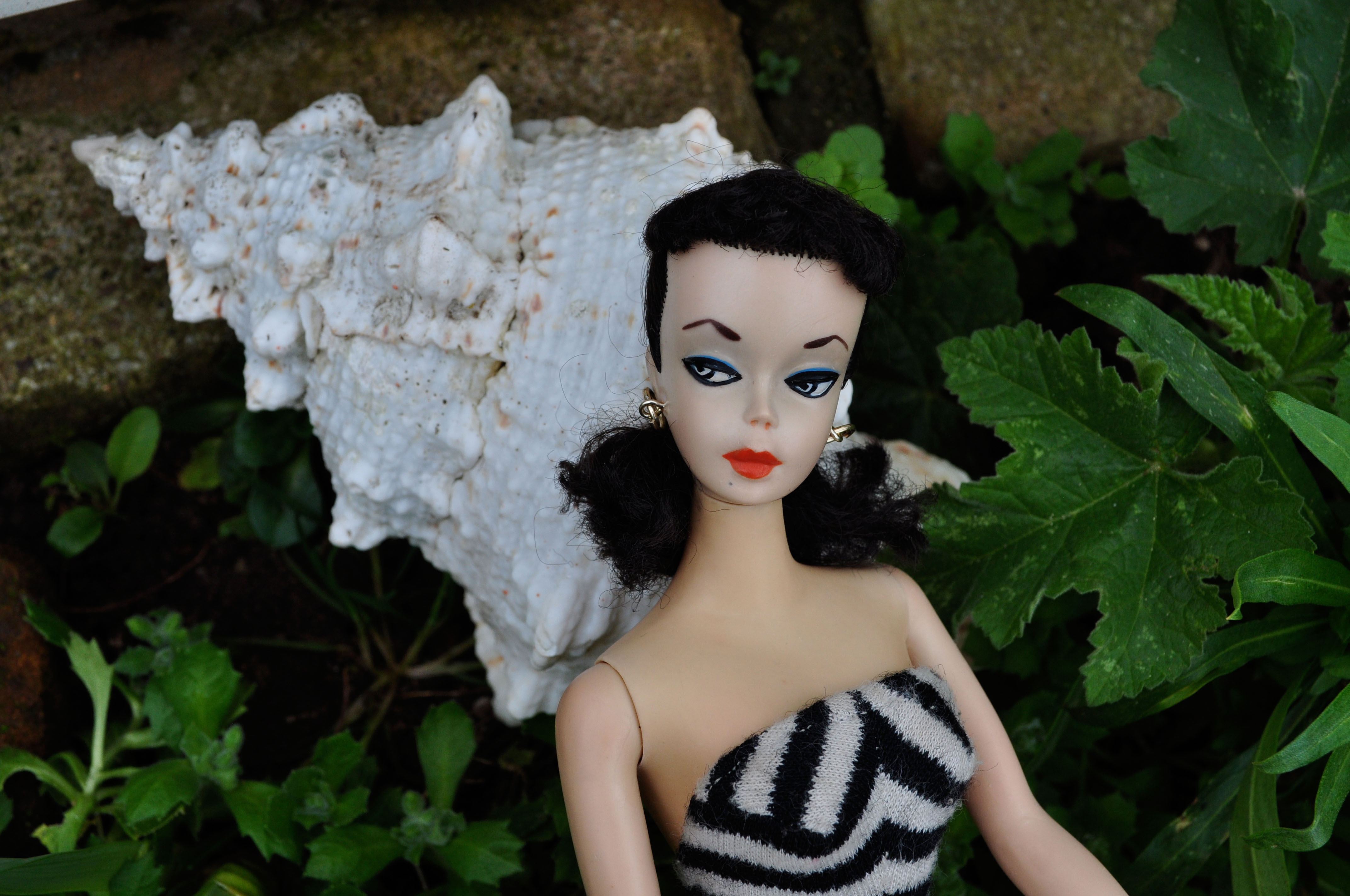 First Barbie doll made in 1959 in Japan, #1 Barbie doll with arched eyebrows, black and white eye paint and matching swimsuit.