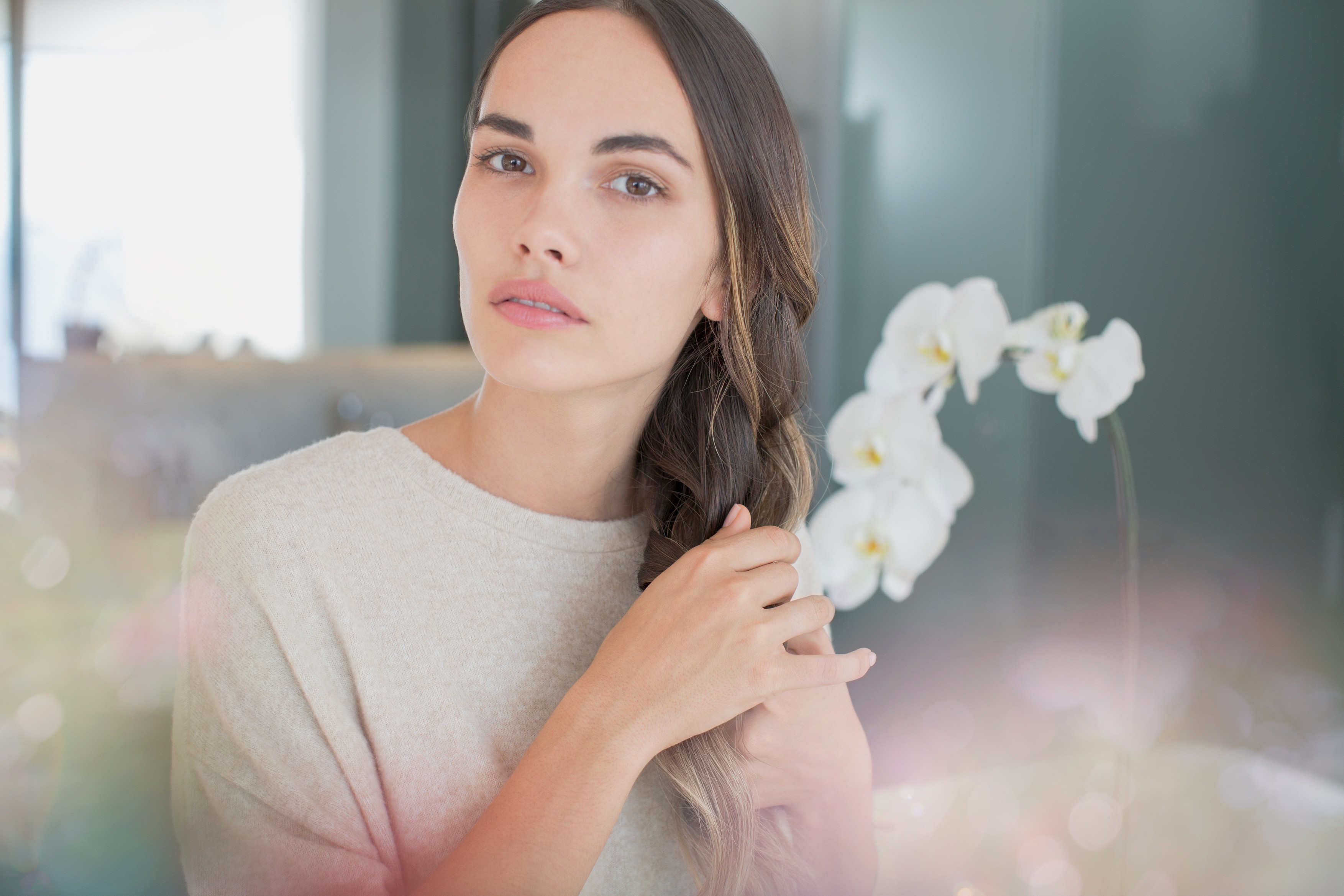 Portrait serious, beautiful brunette woman with hands in hair