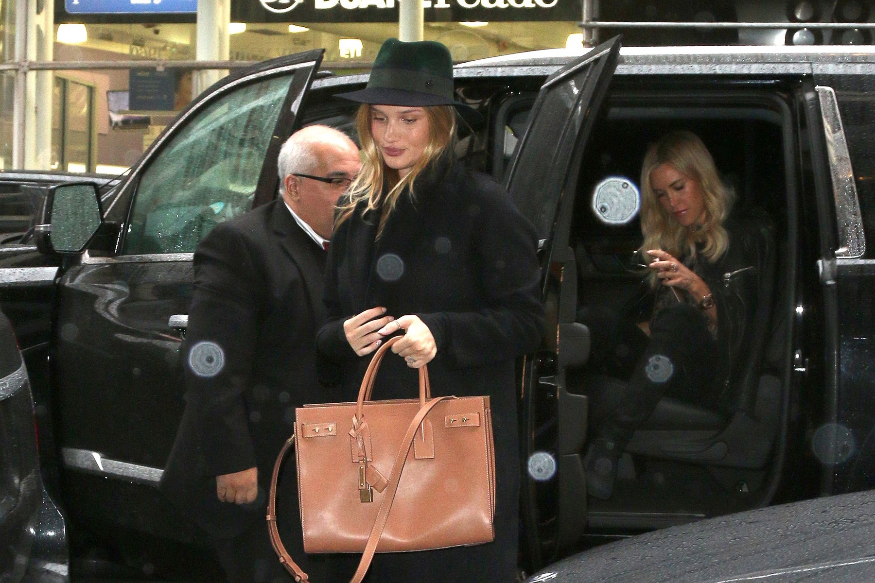 Rosie Huntington-Whiteley hides her bump in the rain