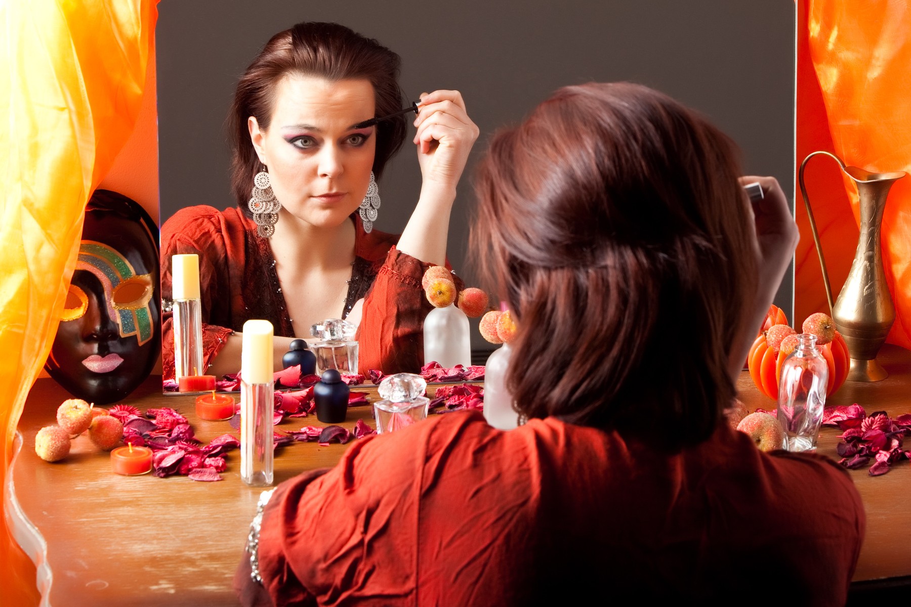Beautiful young woman looking at mirror